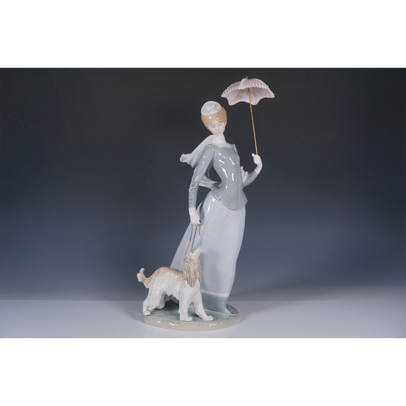 Lladro Porcelain Figurine, Lady with Shawl 1004914: This Lladro porcelain figurine, titled "Lady with Shawl" (1004914), was sculpted by Fulgencio Garcia. The piece depicts an elegant woman holding a parasol while wearing a flowing shawl, capturing Llad