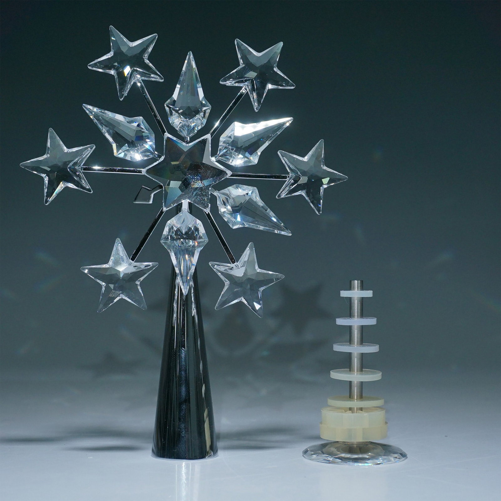 Swarovski Rhodium Christmas Tree Topper with Box: Exquisite Swarovski Christmas Tree Topper, featuring a dazzling rhodium-plated base adorned with precision-cut crystal stars and pointed accents. The intricate design captures and reflects light, crea