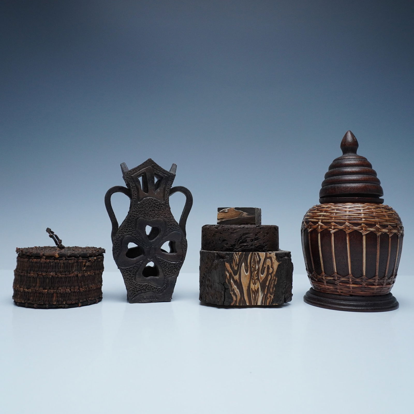 5pc Carved Wood and Fernwood Decorative Boxes and Vessels: This unique 5-piece set features an assortment of hand-carved wooden and fernwood decorative vessels and boxes, showcasing intricate craftsmanship and organic textures. The collection includes a sculp