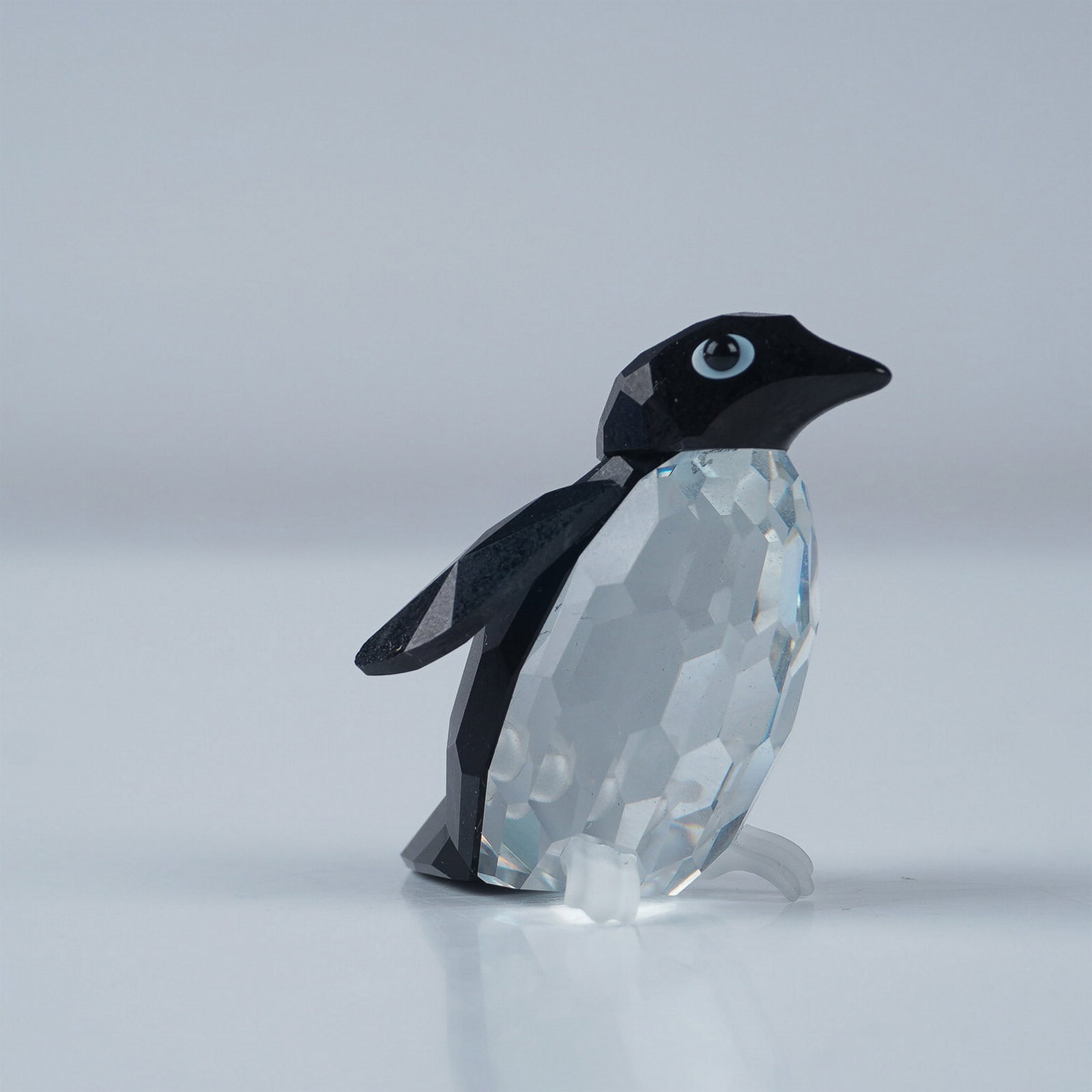 Swarovski Crystal Figurine, Penguin Sir: Swarovski Crystal figurine featuring Penguin Sir, crafted with precision in clear and black faceted crystal. The design showcases a striking contrast with black crystal wings, head, and tail, compleme