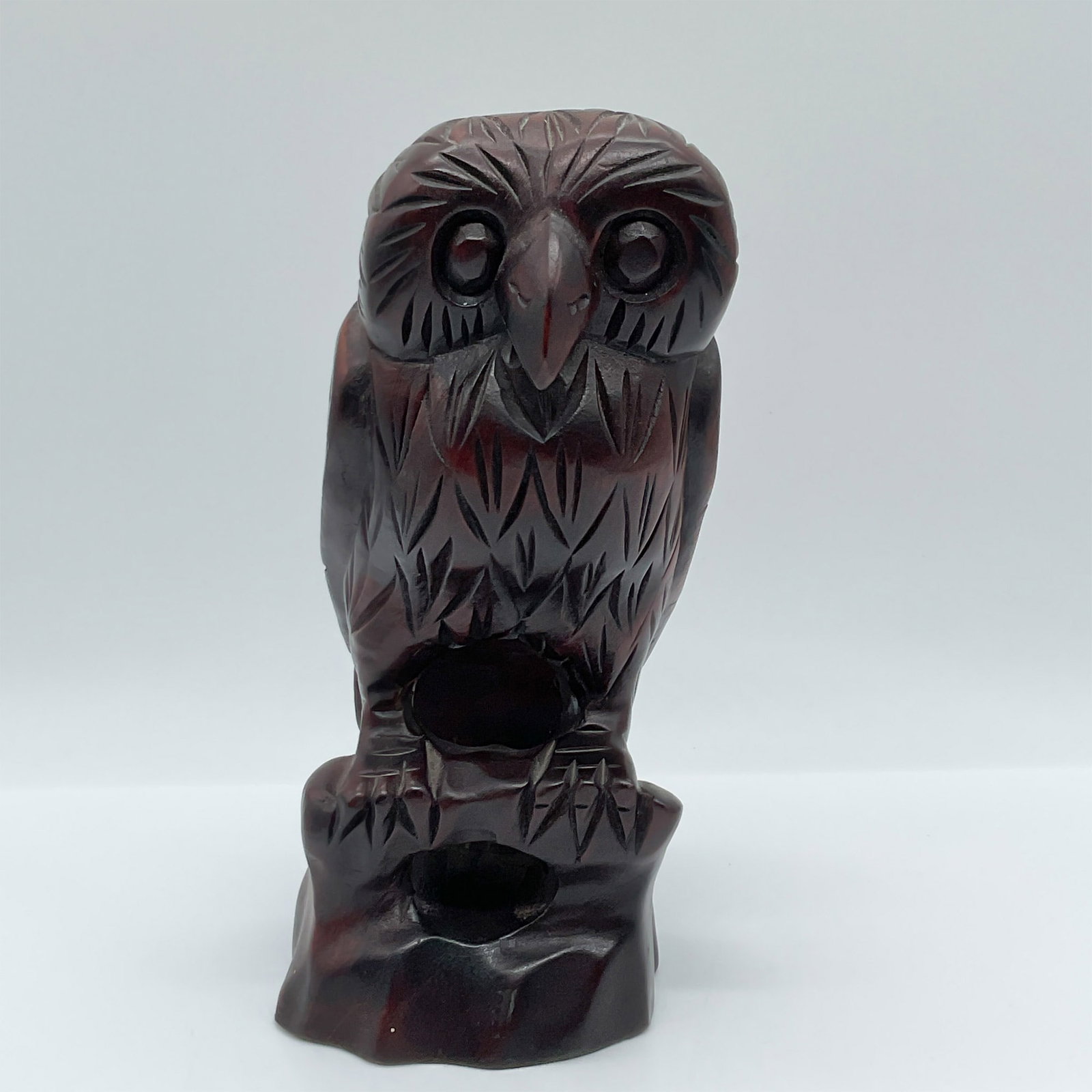 Hand-Carved Wooden Owl Figurine: This intricately hand-carved wooden owl figurine showcases remarkable craftsmanship. The owl is perched on a naturalistic base with detailed feather patterns etched throughout the design. The deep, ri