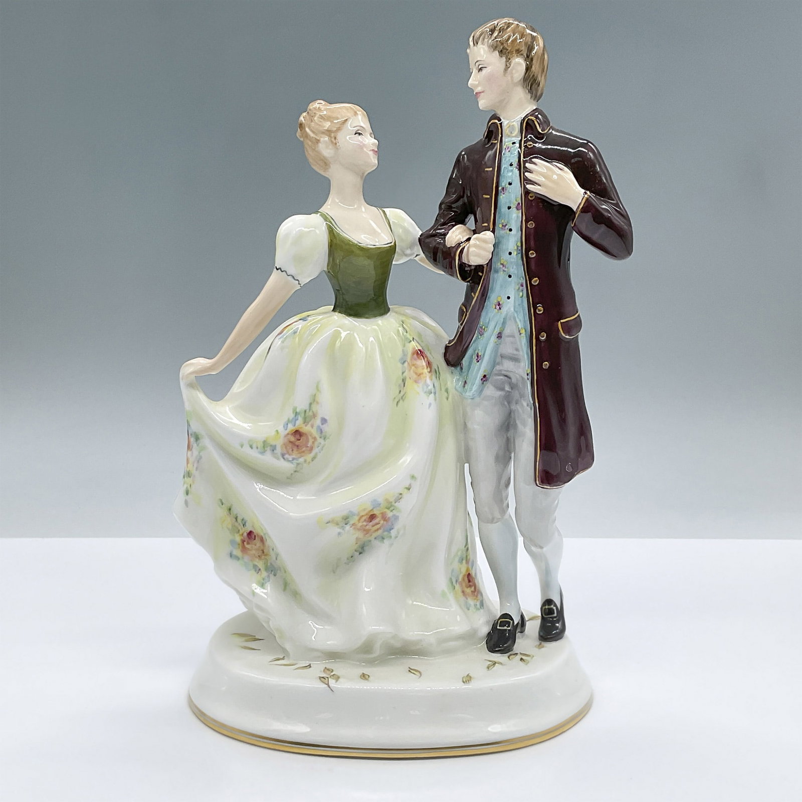 Royal Doulton Bone China Figurine, Young Love HN2735: This enchanting figure features a young couple dancing. The lady is wearing a green and cream colored floral dress and the gentleman a brown coat. Part of the Romantic Theme Series. Royal Doulton back