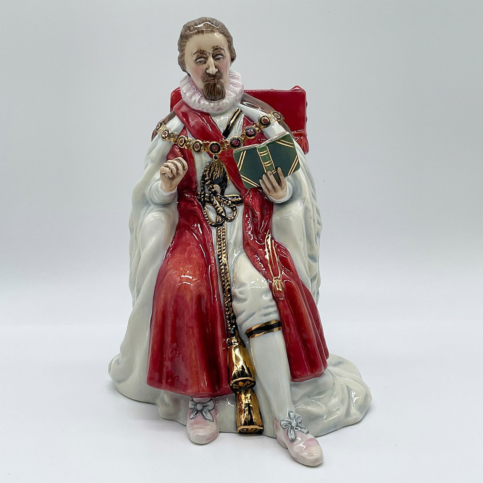 Royal Doulton Porcelain Figurine, King James I HN3822: This Royal Doulton figurine depicts King James I (1566?1625) seated in royal regalia, with a red and white robe adorned with gilded details and an elaborate chain of office. Designed by Douglas V. Too