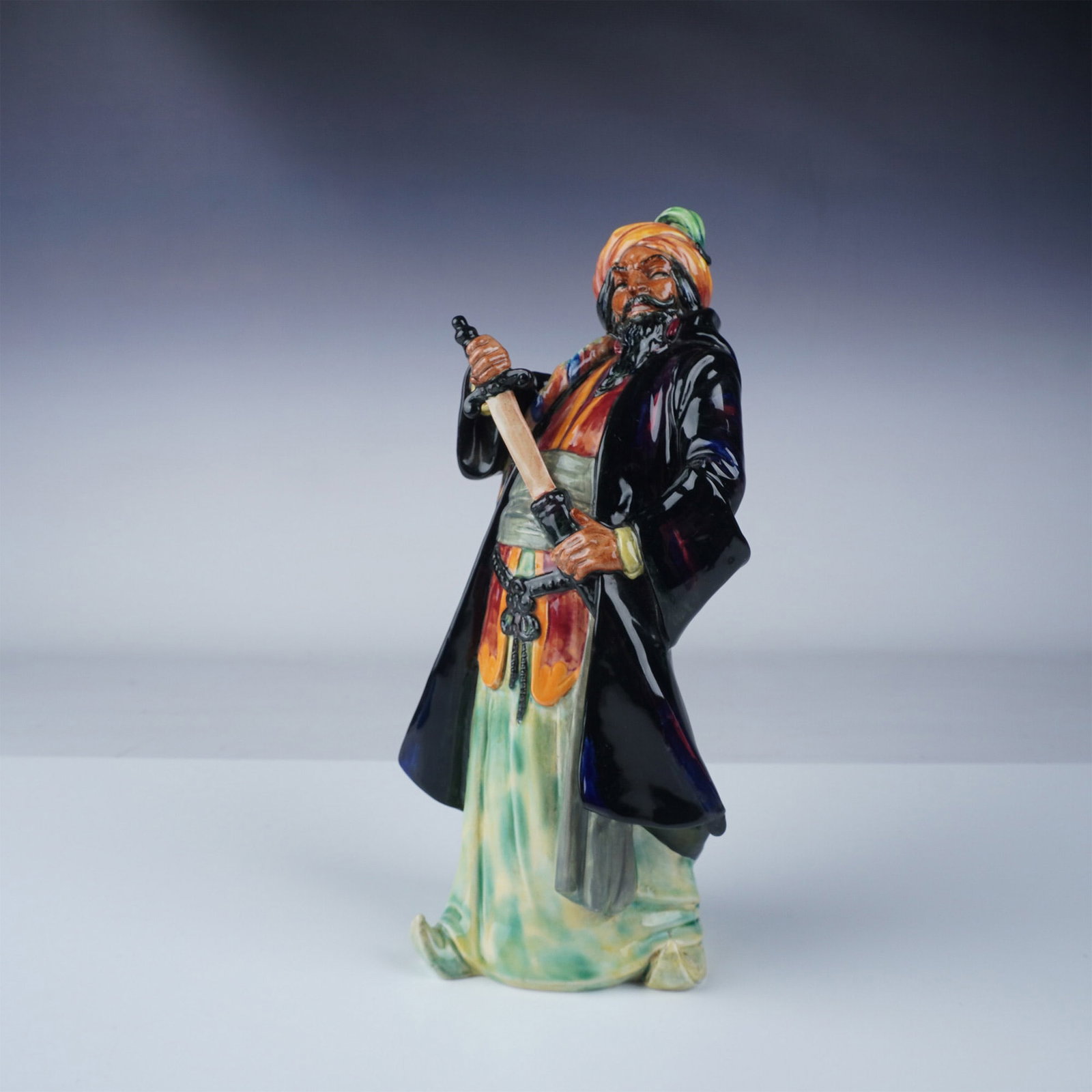 Royal Doulton Figurine, Blue Beard HN2105: Royal Doulton fine bone china figurine titled Blue Beard, model number HN2105. This figurine portrays the legendary Blue Beard character in a dynamic stance, gripping a sword. Featuring vibrant hand-p