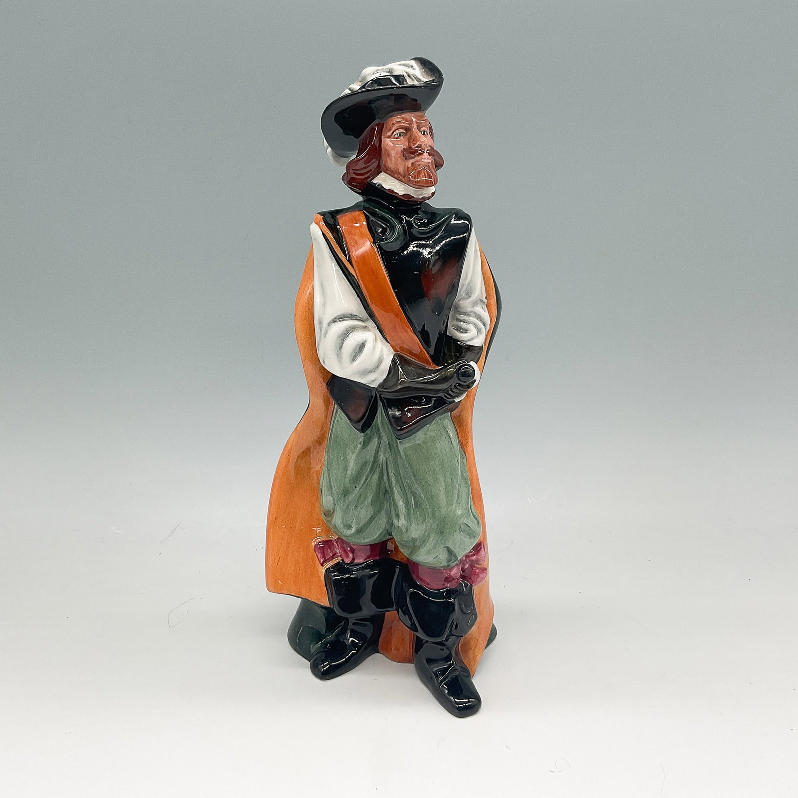 Royal Doulton Figurine, Cavalier HN2716: A finely crafted Royal Doulton figurine titled Cavalier (HN2716), depicting a distinguished 17th-century cavalier in period attire. Designed with remarkable detail, the figure features a feathered hat