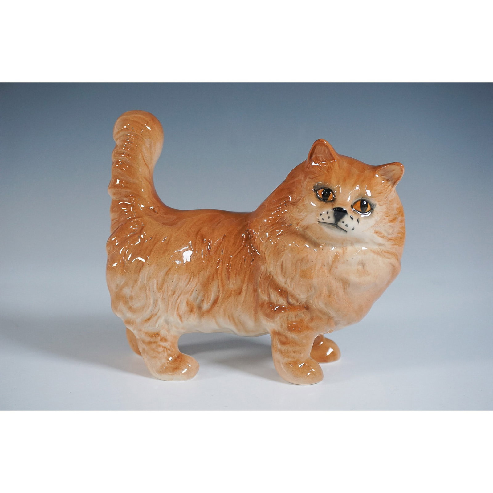Royal Doulton Figurine, Persian Cat - Ginger DA132: This delightful Royal Doulton figurine features a Persian cat in a rich ginger tone, expertly rendered to highlight the breed's distinctive long-haired coat and regal demeanor. The glossy finish accen