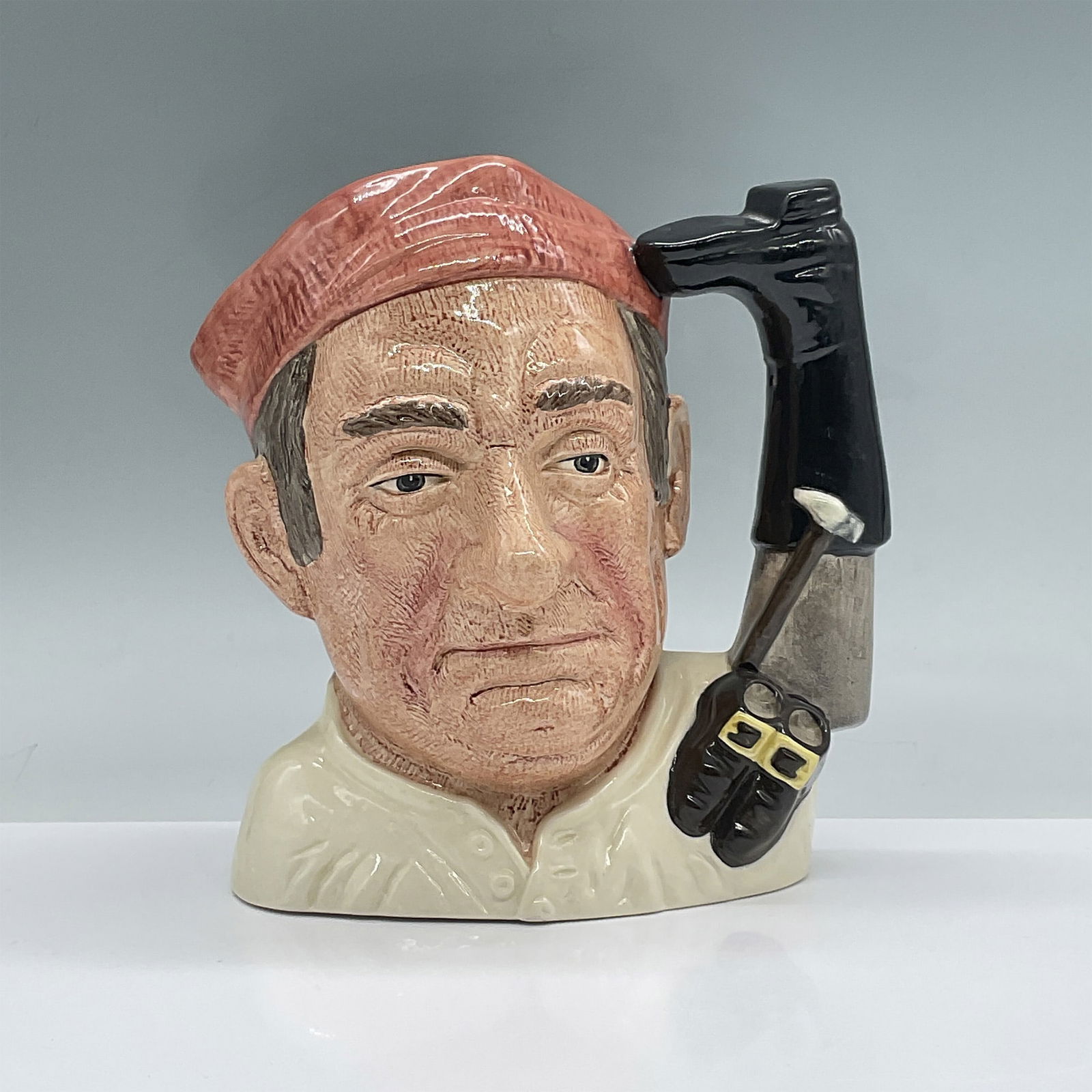 Bootmaker D6572 - Large - Royal Doulton Character Jug: Salmon cap, white shirt. Royal Doulton backstamp. Artist: David B. Biggs Issued: 1963 - 1983 Dimensions: 7.5"H Country of Origin: England