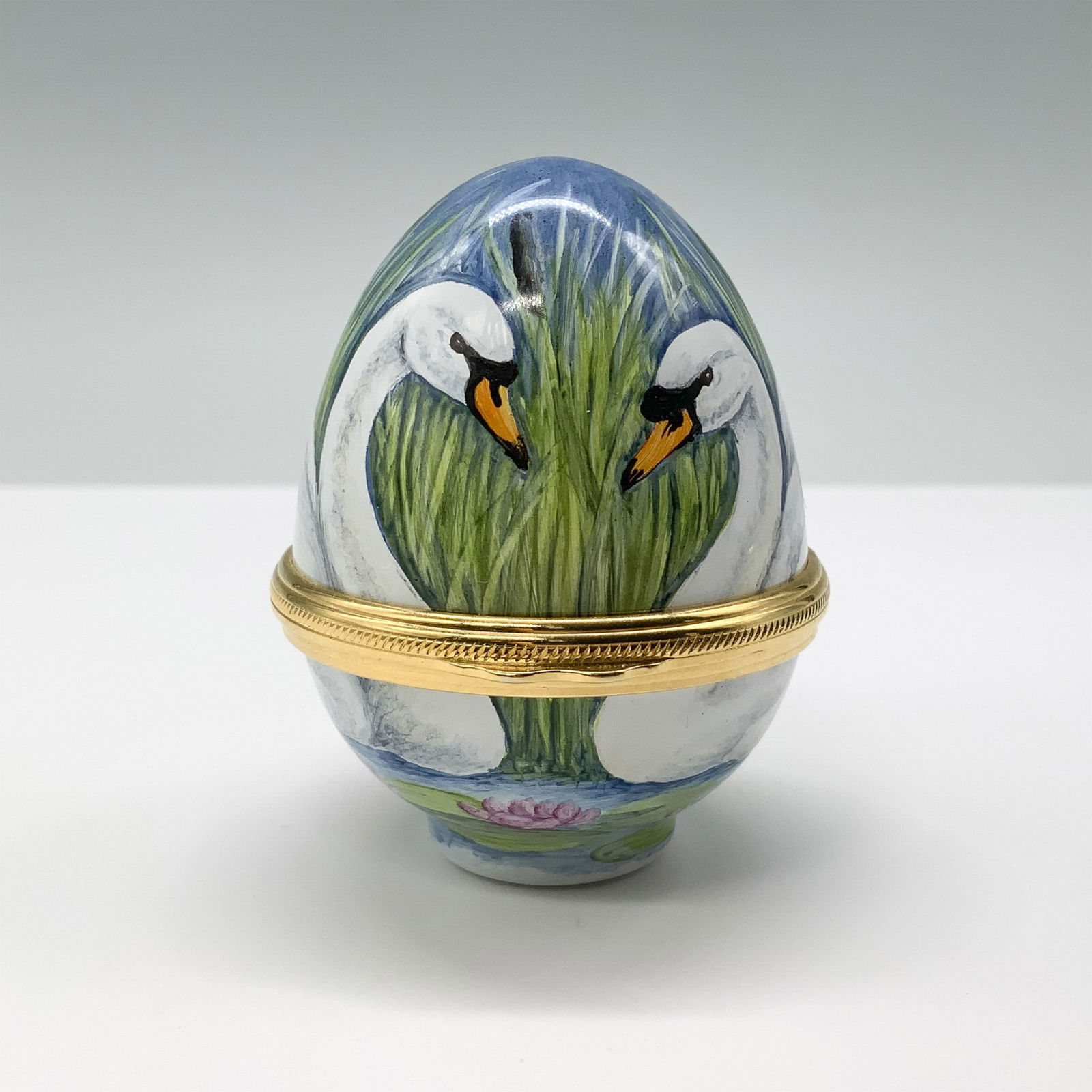 Elliot Hall Enamel Swan Egg Shaped Box: This stunning egg-shaped enamel box is a fine creation by Elliot Hall Enamels, a renowned British brand celebrated for its exquisite hand-painted designs and superior craftsmanship. This particular eg