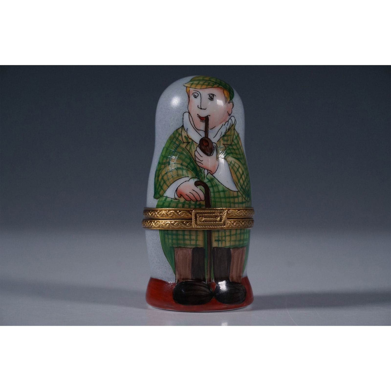 Limoges Figurine Box, Sherlock Holmes Nesting Dolls: Hand-painted Limoges porcelain figurine box featuring a nesting doll design inspired by Sherlock Holmes. The hinged box opens to reveal two smaller figurines, including Dr. Watson and a miniature magn