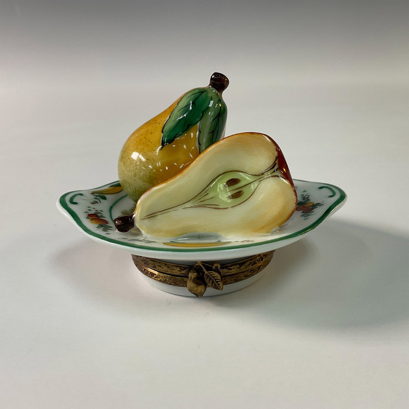 Limoges French Pear Theme Collectible Box: Charming porcelain treasure box, handcrafted in Limoges, France. This limited edition piece is beautifully depicted as a decorative plate adorned with realistic pears, including a halved pear showcasi