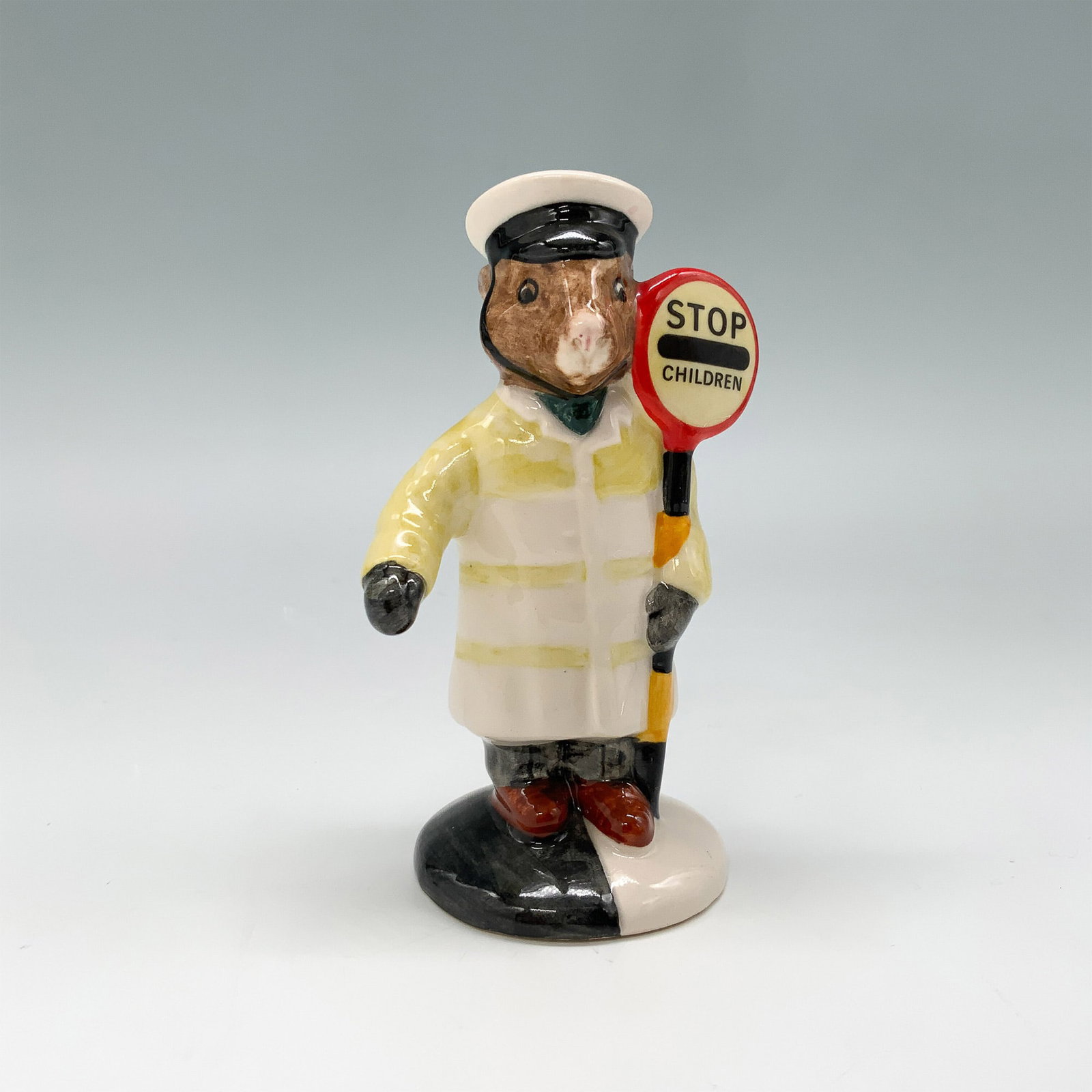 Royal Doulton Bunnykins Figurine, Lollipopman DB65: Royal Doulton Bunnykins figurine titled Lollipopman, model DB65. Crafted from fine bone china, this charming figurine depicts a Bunnykins character dressed as a crossing guard, holding a Stop Children