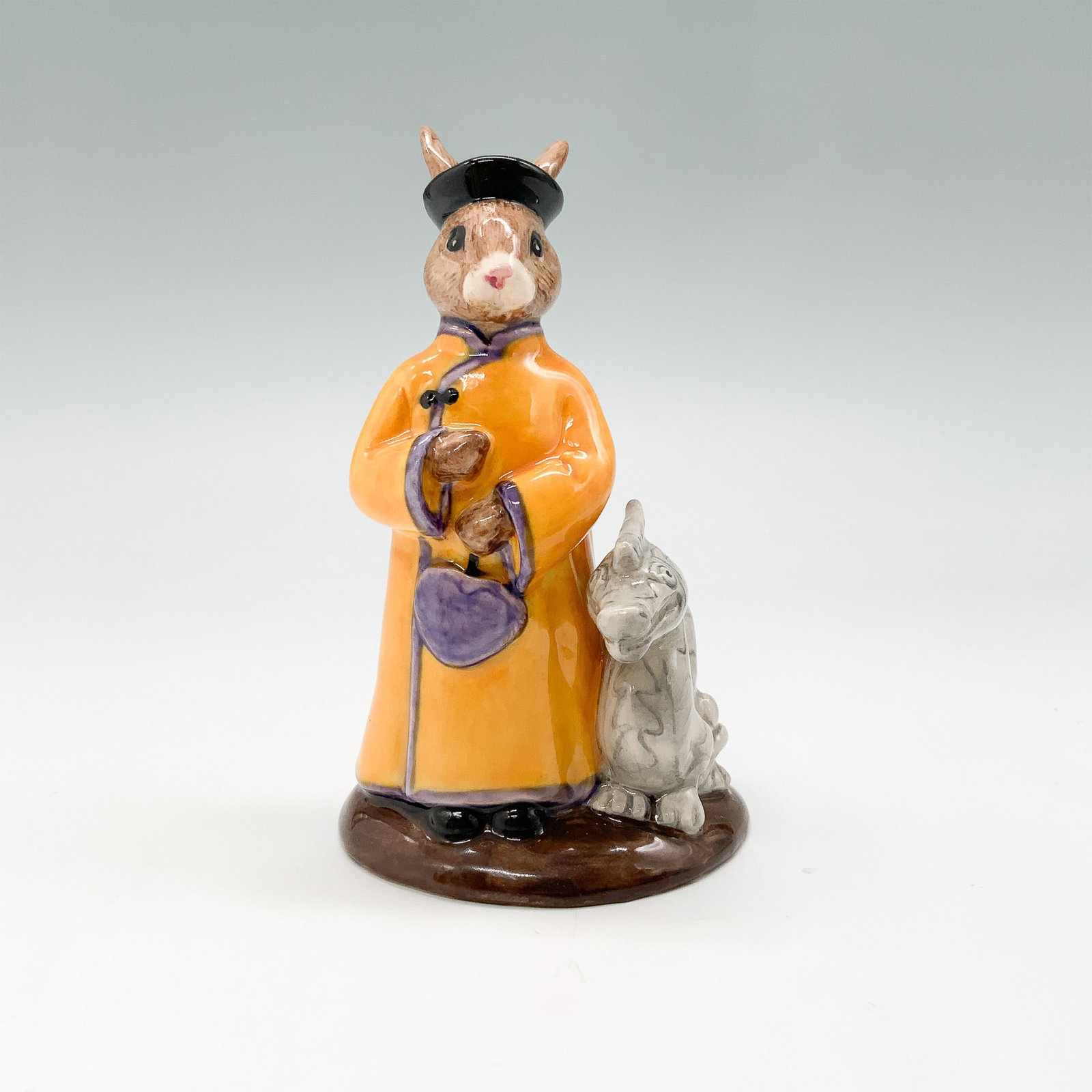 Royal Doulton Bunnykins Figurine, Mandarin DB252: This charming Royal Doulton Bunnykins figurine, titled "Mandarin," is part of the "Bunnykins of the World" series. Designed by Caroline Dadd in 2001, it showcases a delightful rabbit dressed in tradit