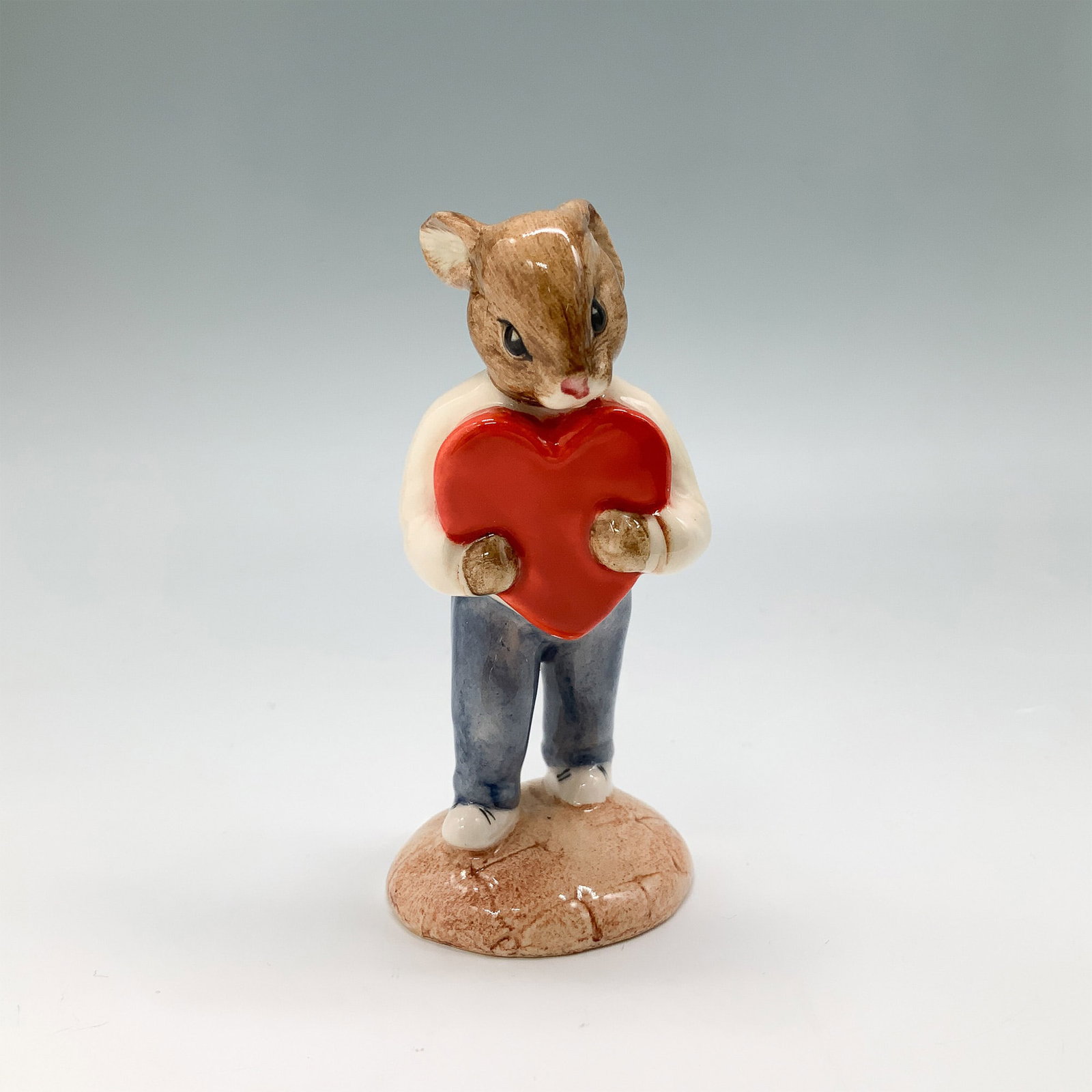 Royal Doulton Bunnykins Sweetheart Figurine DB130: This charming Royal Doulton Bunnykins figurine, titled 'Sweetheart' (DB130), features a delightful bunny dressed in a yellow sweater and blue trousers, holding a large red heart. Designed by Graham To