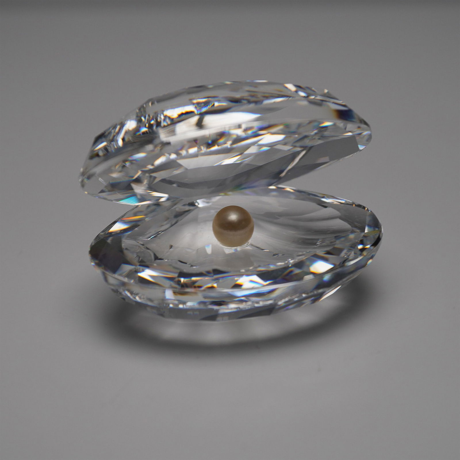 Swarovski Crystal Shell with Pearl Figurine with Original Box: Swarovski Crystal Shell with Pearl, model number 014389, designed by Michael Stamey. This elegant figurine features a beautifully faceted clear crystal shell with an iridescent pearl nestled inside. P