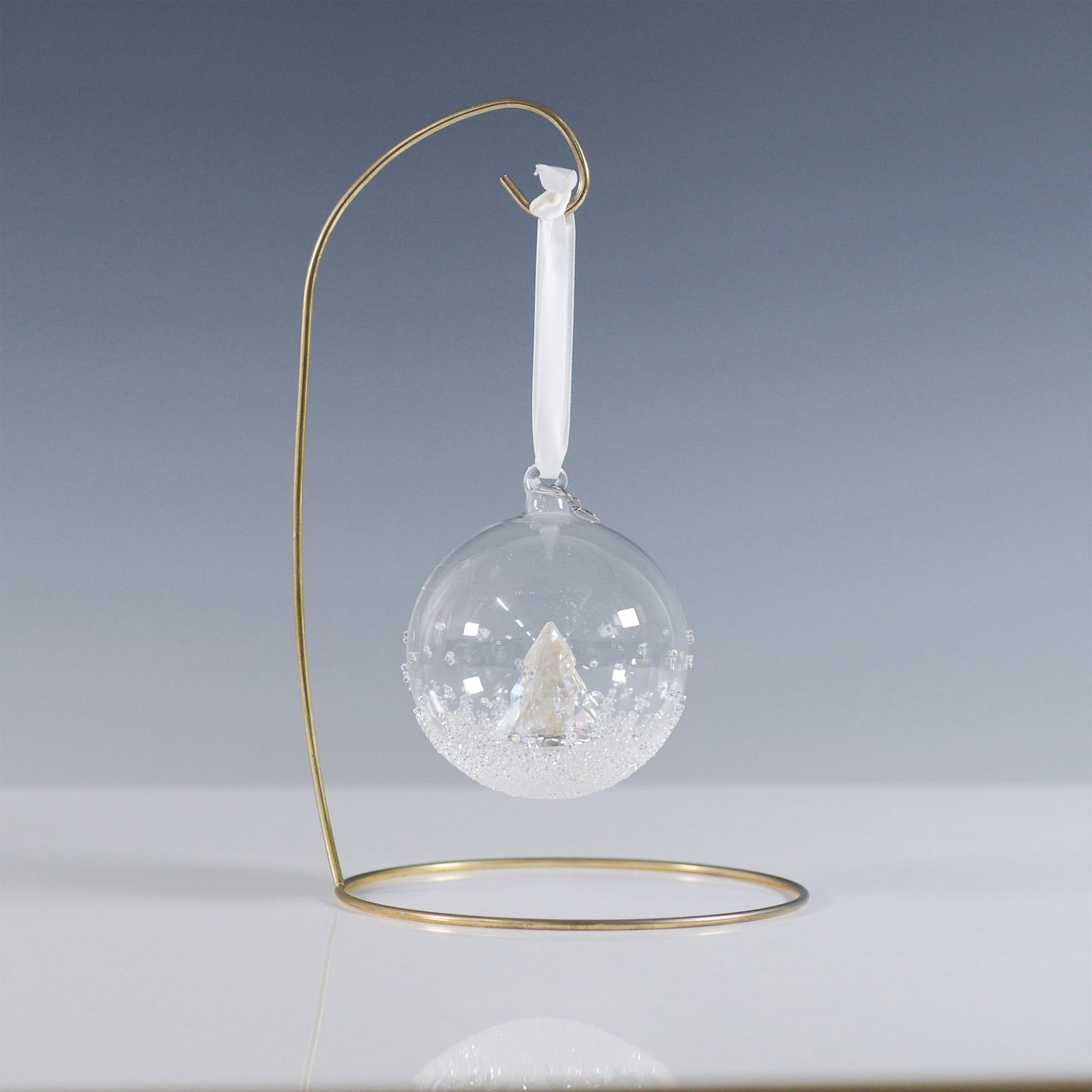 Swarovski Annual Edition Christmas Ball Ornament: A dazzling Swarovski Christmas Ball Ornament from 2013, featuring a delicate hand-blown glass bell with a faceted clear crystal star suspended inside. The ornament is adorned with a white satin ribbon