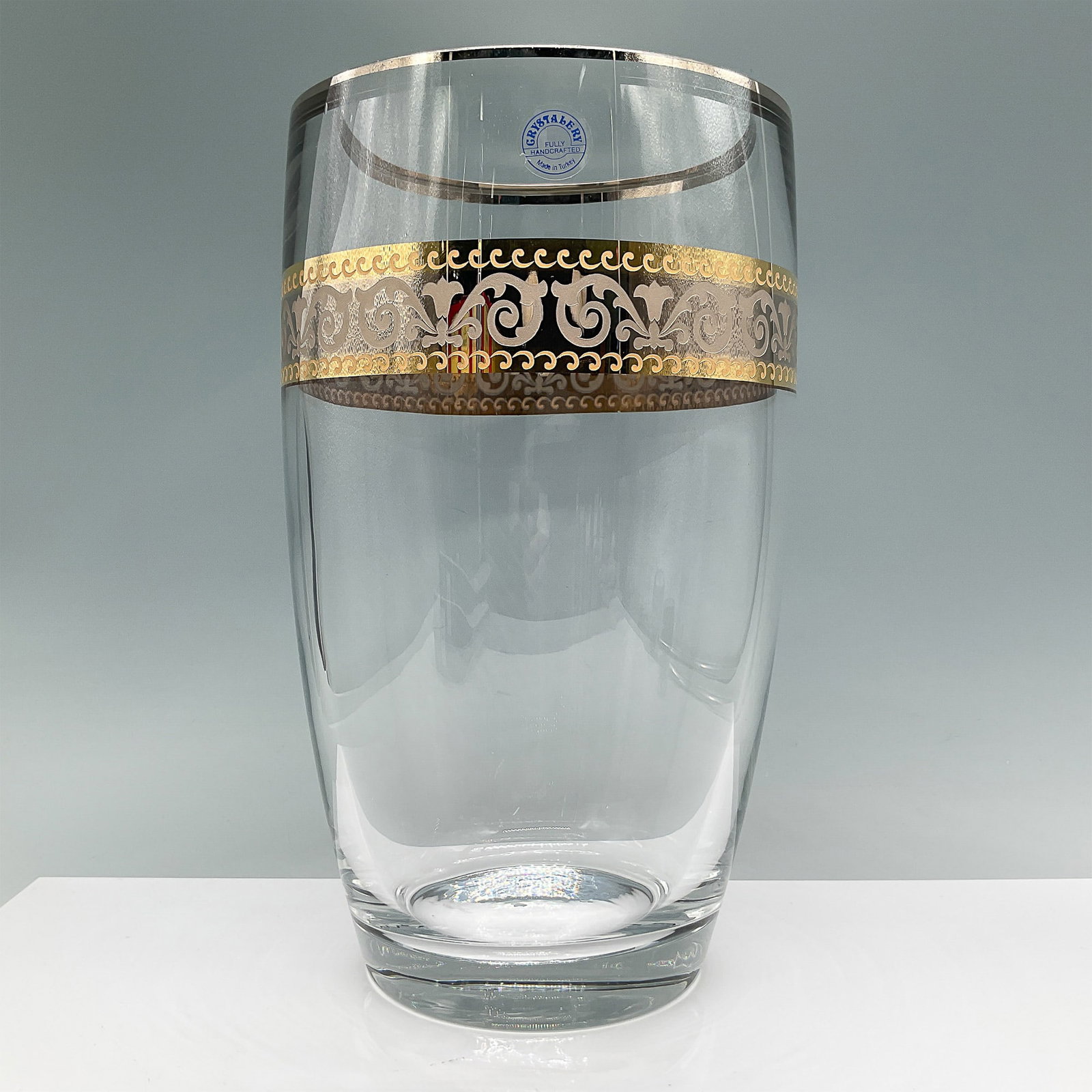 Crystalex Glass Vase, Gold and Silver Etched Design: This fully handcrafted vase by Crystalex, made in Turkey, features an intricate etched gold and silver band with ornamental scrollwork. Measuring 11"H, the vase exhibits exceptional craftsmanship with