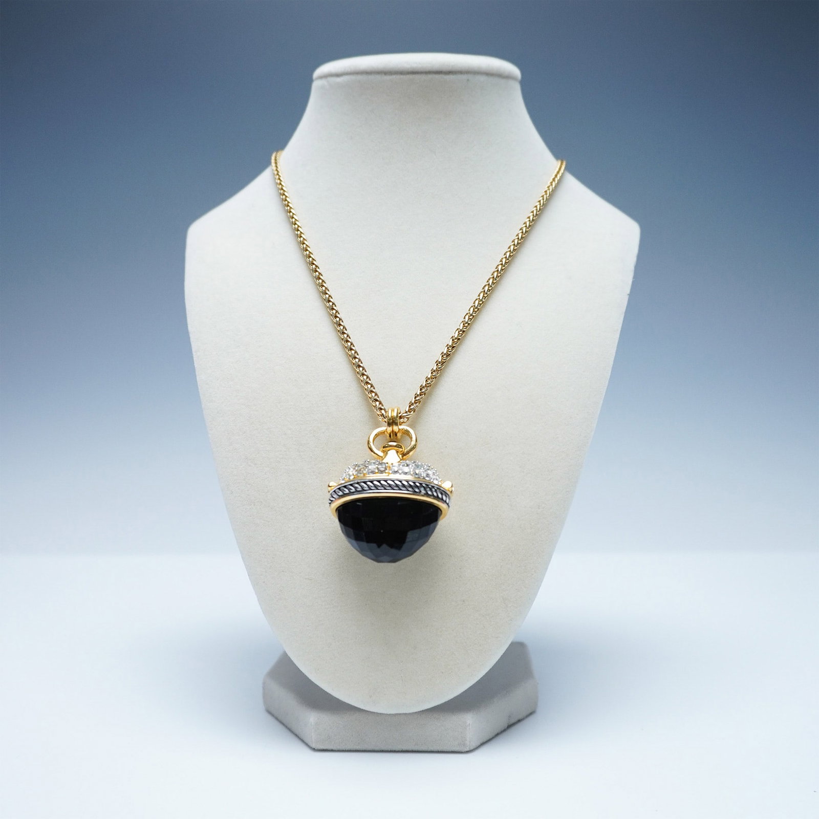 Joan Rivers Gold Tone and Black Pendant Necklace: A striking gold-tone necklace by Joan Rivers, featuring a faceted black stone encased in an ornate, rhinestone-studded pendant with enamel detailing. The pendant opens to reveal a hidden compartment, 
