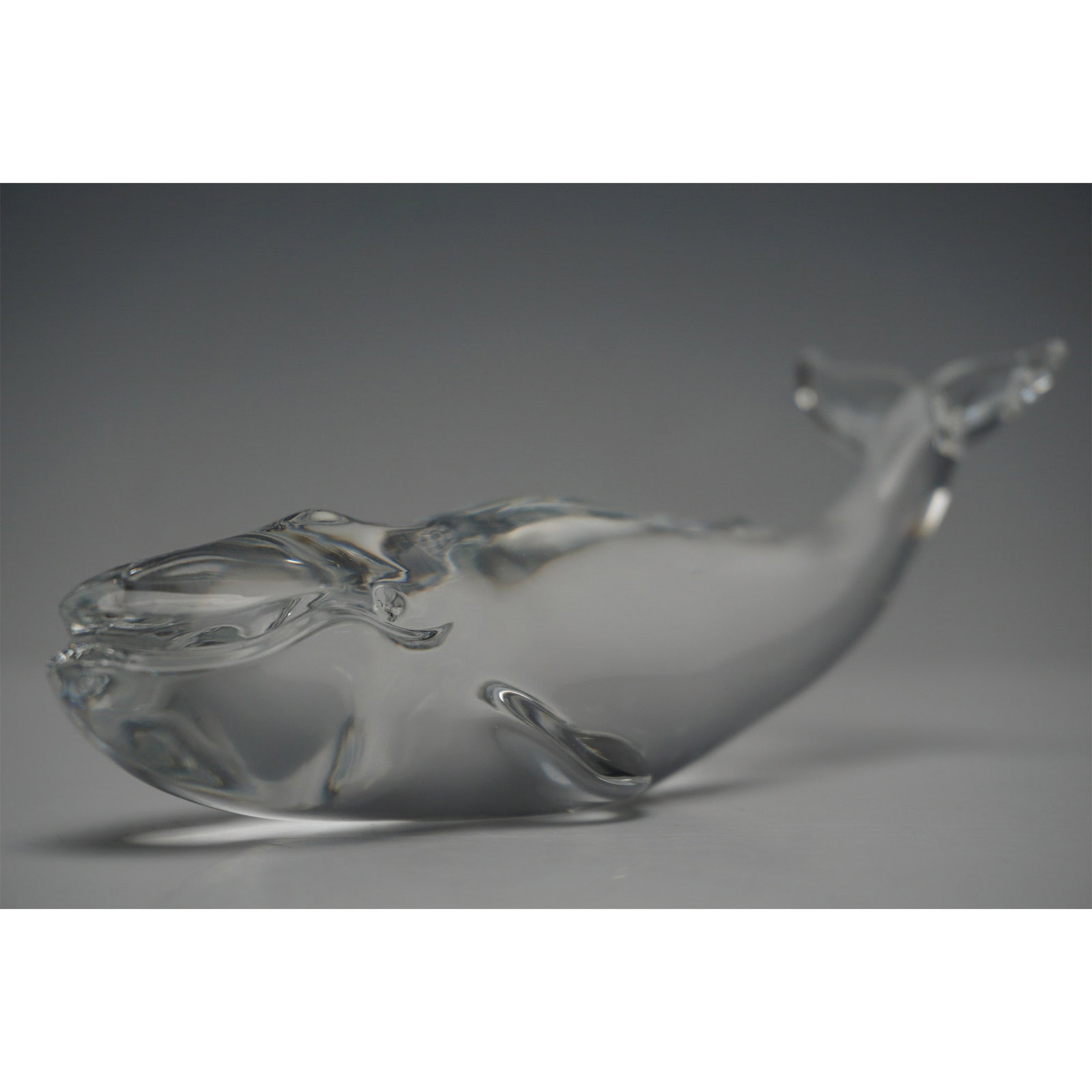 Baccarat Crystal Whale Figurine: Elegant Baccarat crystal whale figurine, expertly crafted with smooth contours and exquisite clarity. The piece features the iconic Baccarat France acid-etched backstamp, ensuring authenticity. Its sc