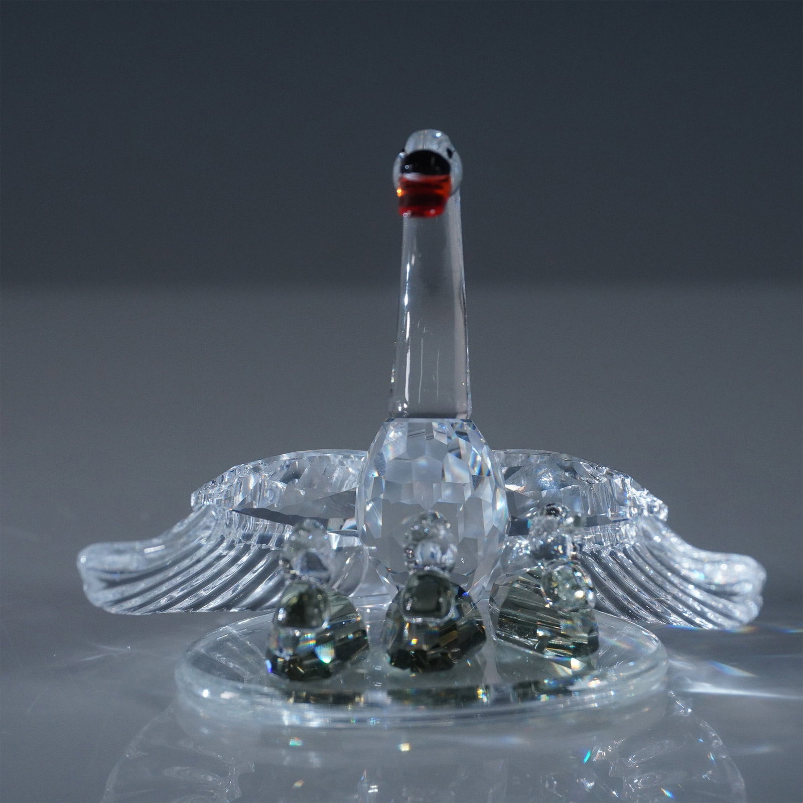 Swarovski Crystal Figurine, Swan Family: This elegant Swarovski Crystal figurine showcases a graceful swan with three cygnets nestled within its outspread wings, capturing the essence of family and protection. Crafted with intricate detailin