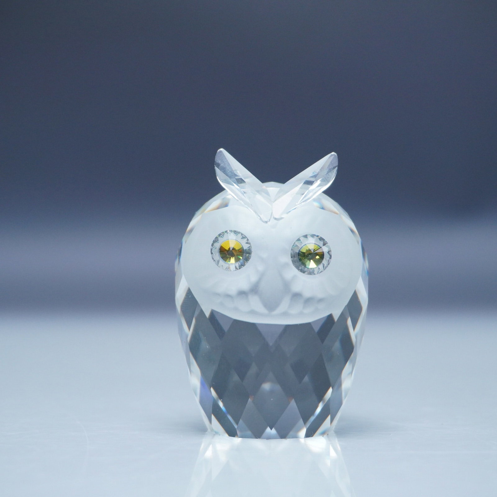 Swarovski Crystal Figurine, Small Owl Woodland Friends: Swarovski crystal figurine featuring a small owl from the Woodland Friends collection. The owl is crafted from clear faceted crystal with a frosted face and detailed crystal ears. It has striking yell