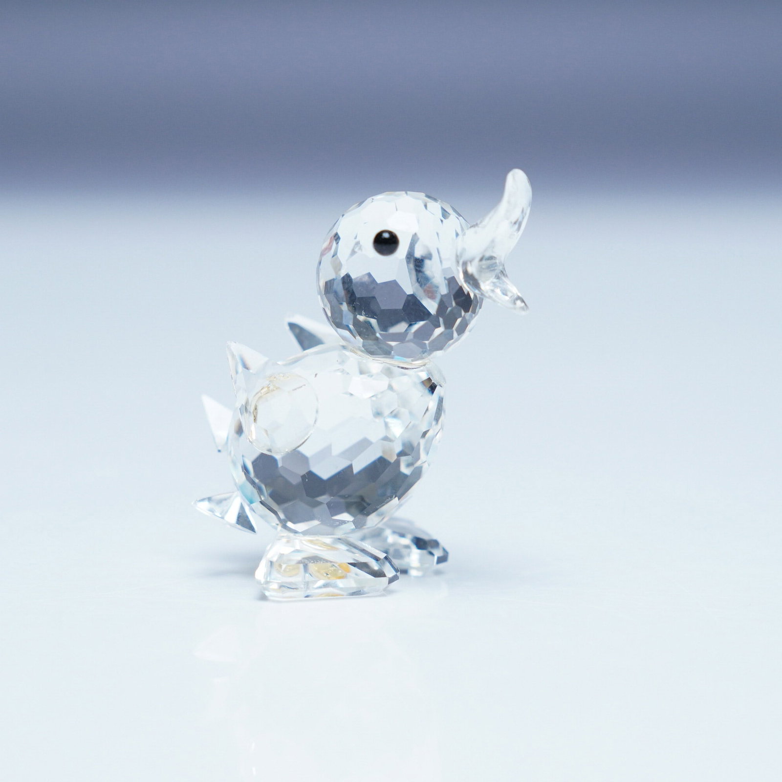 Swarovski Crystal Figurine, Mini Drake: This Swarovski crystal figurine features the Mini Drake from the Beauties of the Lake collection. The drake has a faceted crystal body, a molded open beak, and black eyes, capturing the elegance and c