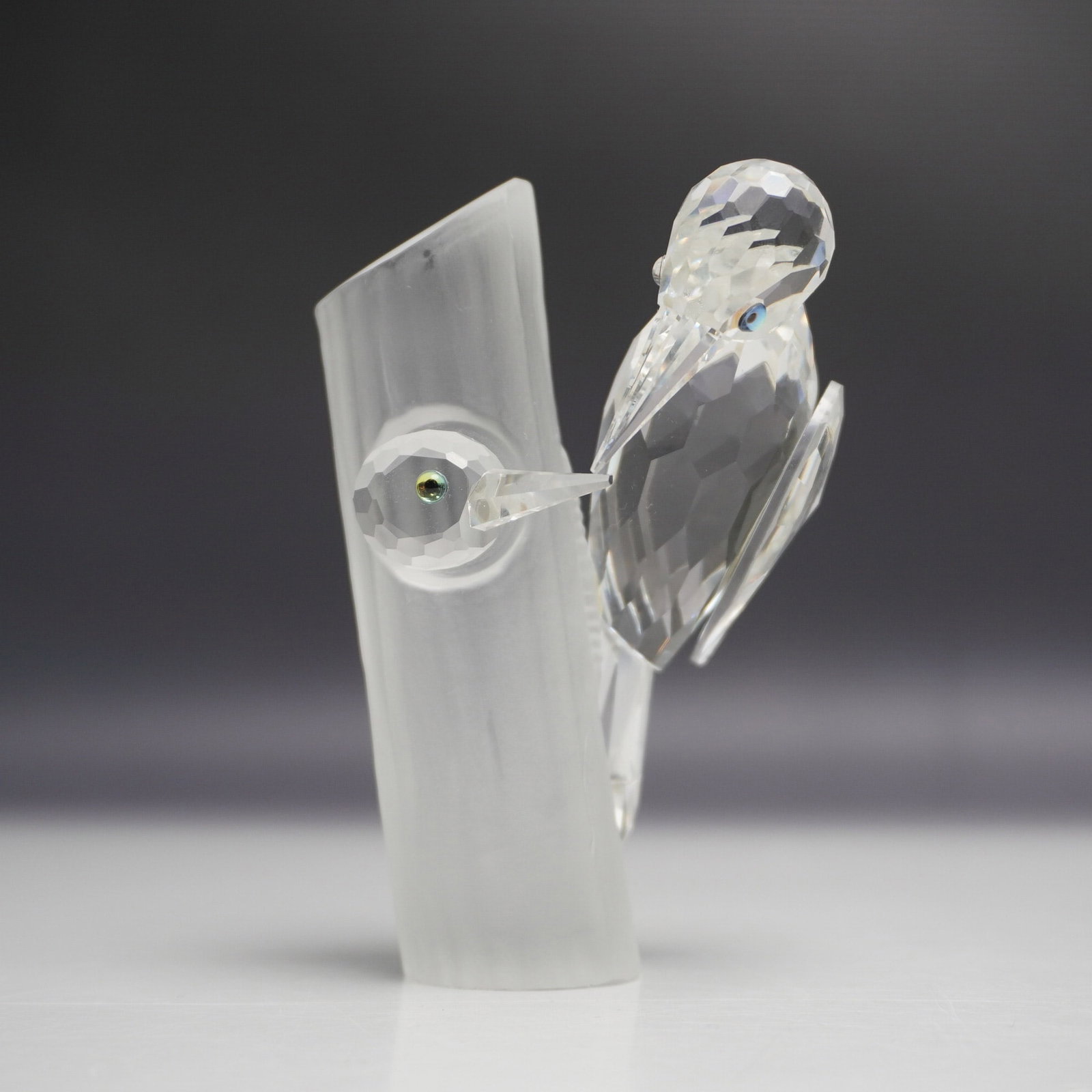 Swarovski SCS 1988 Woodpecker Crystal Figurine: A Swarovski SCS Woodpeckers crystal figurine, released in 1988 as part of the Caring and Sharing series. This stunning piece features two intricately crafted woodpeckers perched on a frosted crystal t
