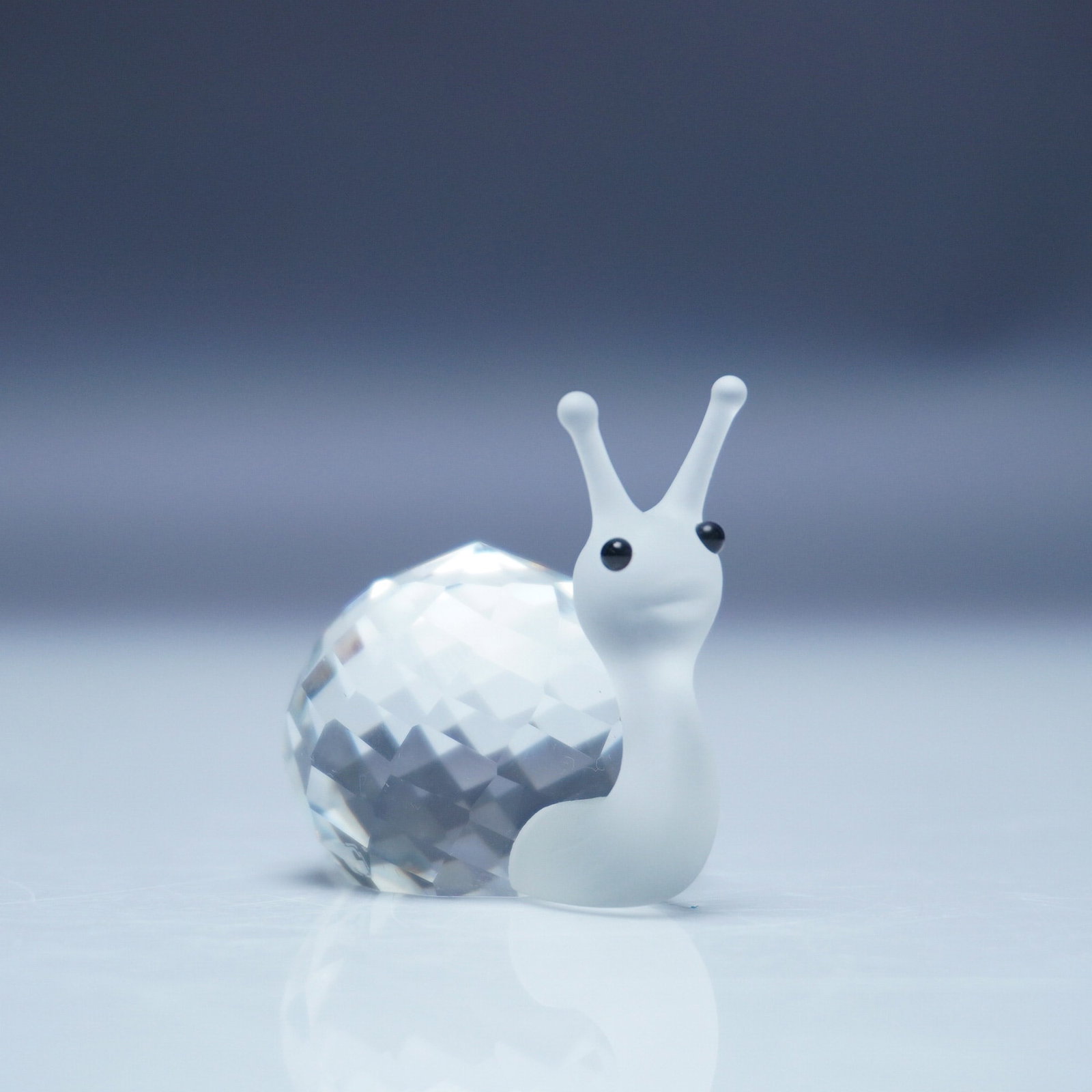 Swarovski Crystal Figurine, Snail: Charming Swarovski crystal figurine of a snail from the In a Summer Meadow collection. This delicate piece features a faceted clear crystal shell and a clear body with a frosted head, neck, and tail. 
