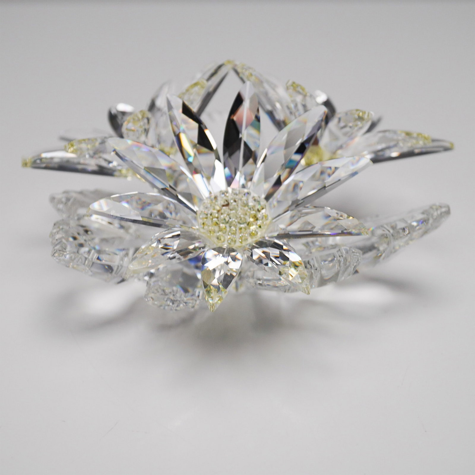Swarovski Crystal Figurine, Maxi Flower Arrangement: Exquisite Swarovski crystal floral arrangement from the "Secret Garden" theme. This stunning piece features three faceted clear crystal flowers resting on a clear crystal base. Each flower's center is