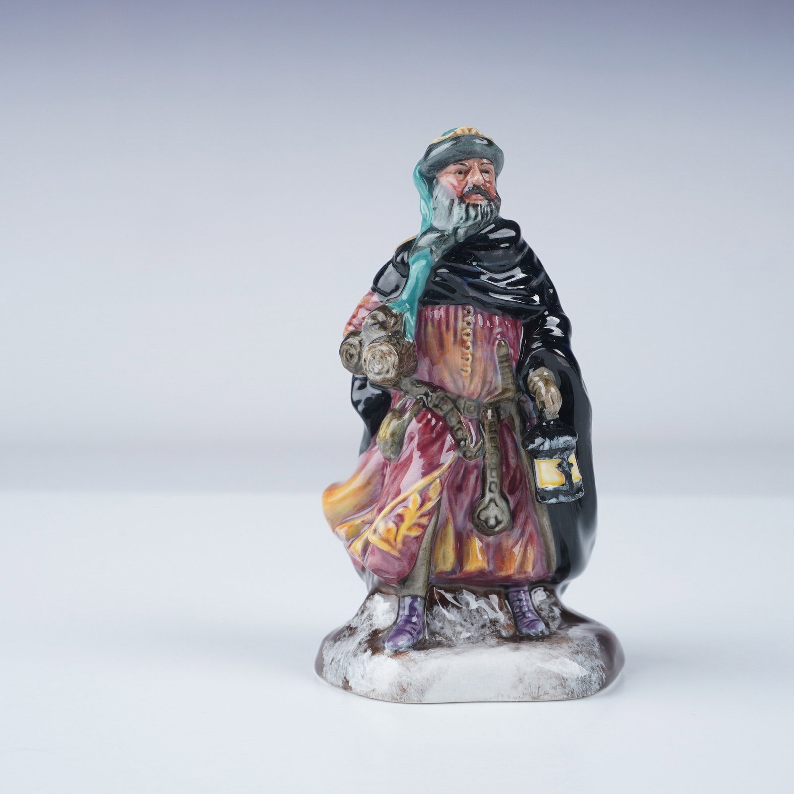 Royal Doulton Mini Figurine, Good King Wencelas HN3262: Royal Doulton Good King Wenceslas HN3262, a finely crafted ceramic figurine designed by Peggy Davies and issued in 1952. This detailed hand-painted piece depicts the legendary Bohemian king in a flowi