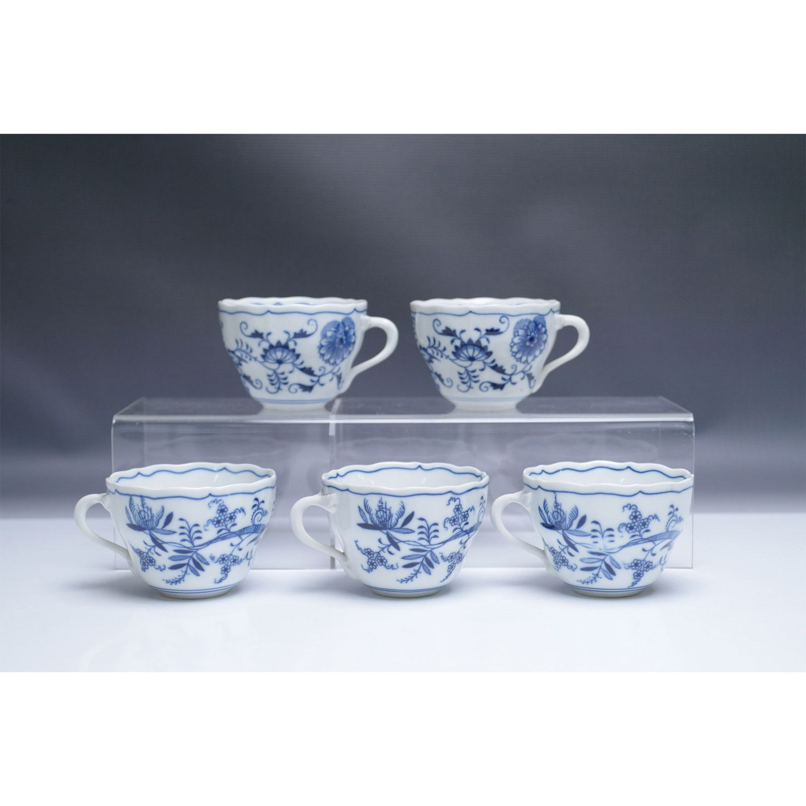 5pc Zwiebelmuster Czechoslovakia Blue Onion Porcelain Cups: A set of five porcelain tea cups in the traditional Zwiebelmuster (Blue Onion) pattern, produced in Czechoslovakia. These finely crafted cups feature intricate cobalt blue floral and foliage designs o