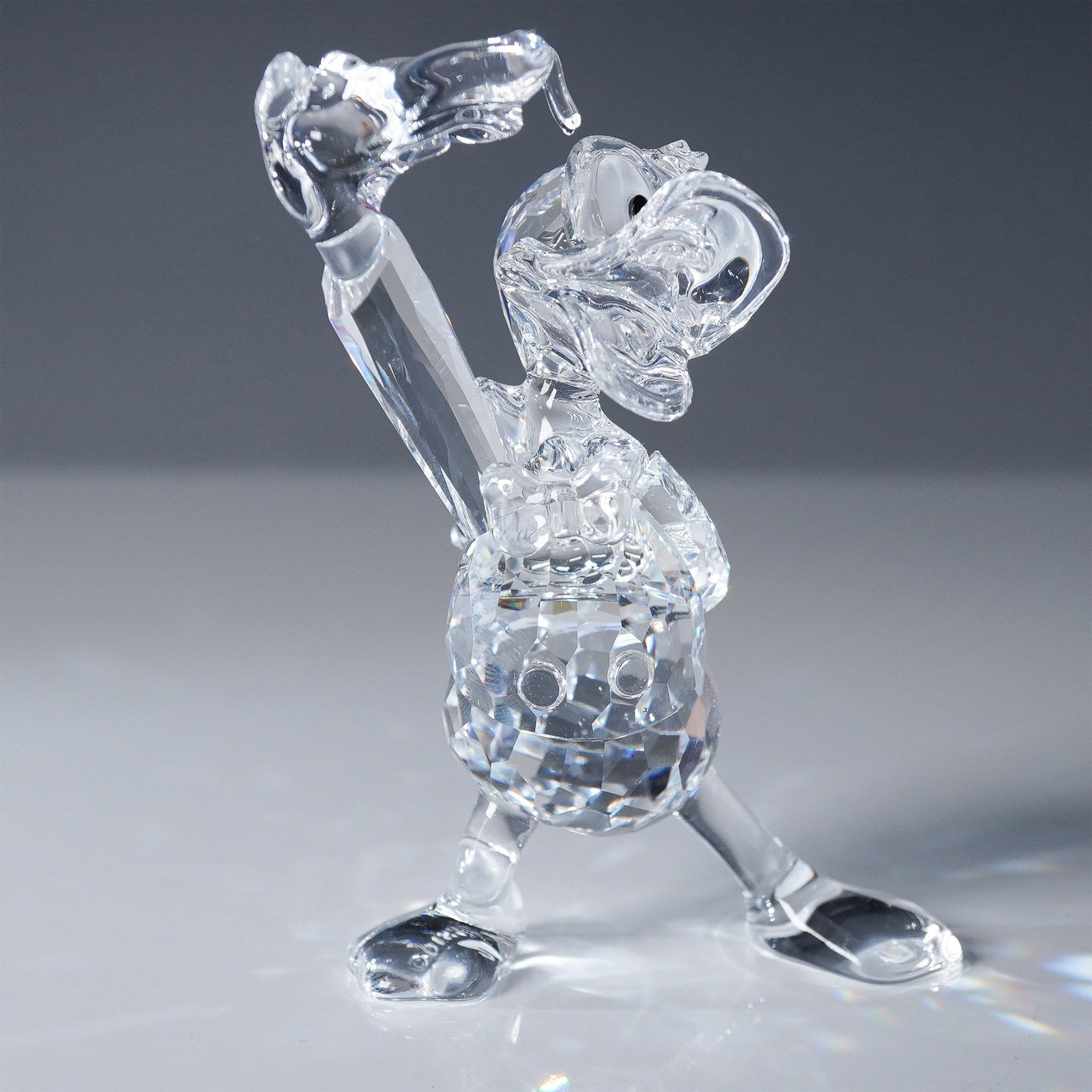 Swarovski Crystal Figurine, Disney's Donald Duck: This Swarovski crystal figurine features Disney's Donald Duck in a dynamic pose, capturing his signature animated charm. Part of the Swarovski Disney collection, this intricately faceted crystal figur