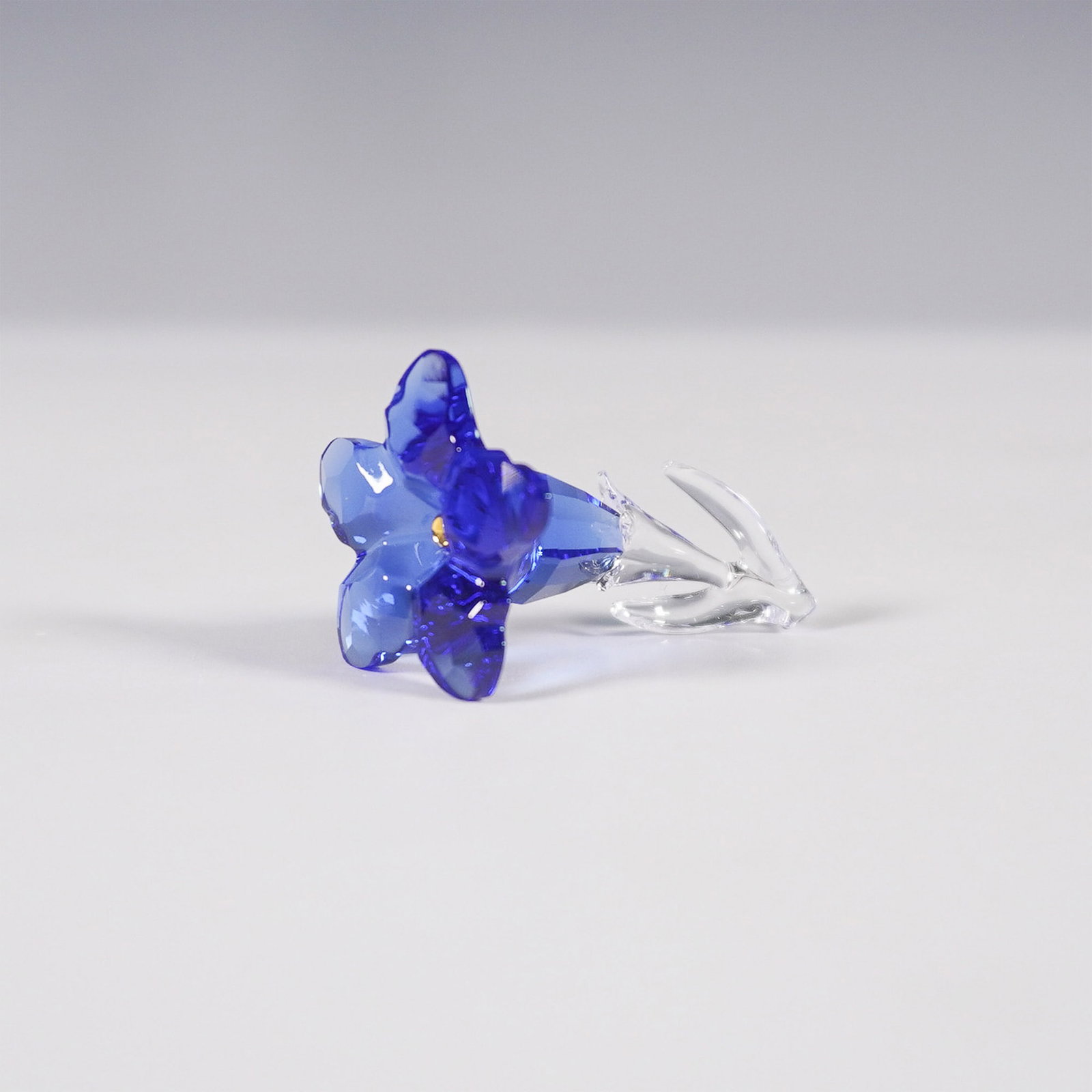 Swarovski Crystal Figurine, Gentian 5490321: Swarovski crystal figurine featuring the SCS Gentian flower, a membership gift issued in 2020. Inspired by the trumpet-shaped gentian flowers found in the Tyrolean Alps, this piece showcases faceted S