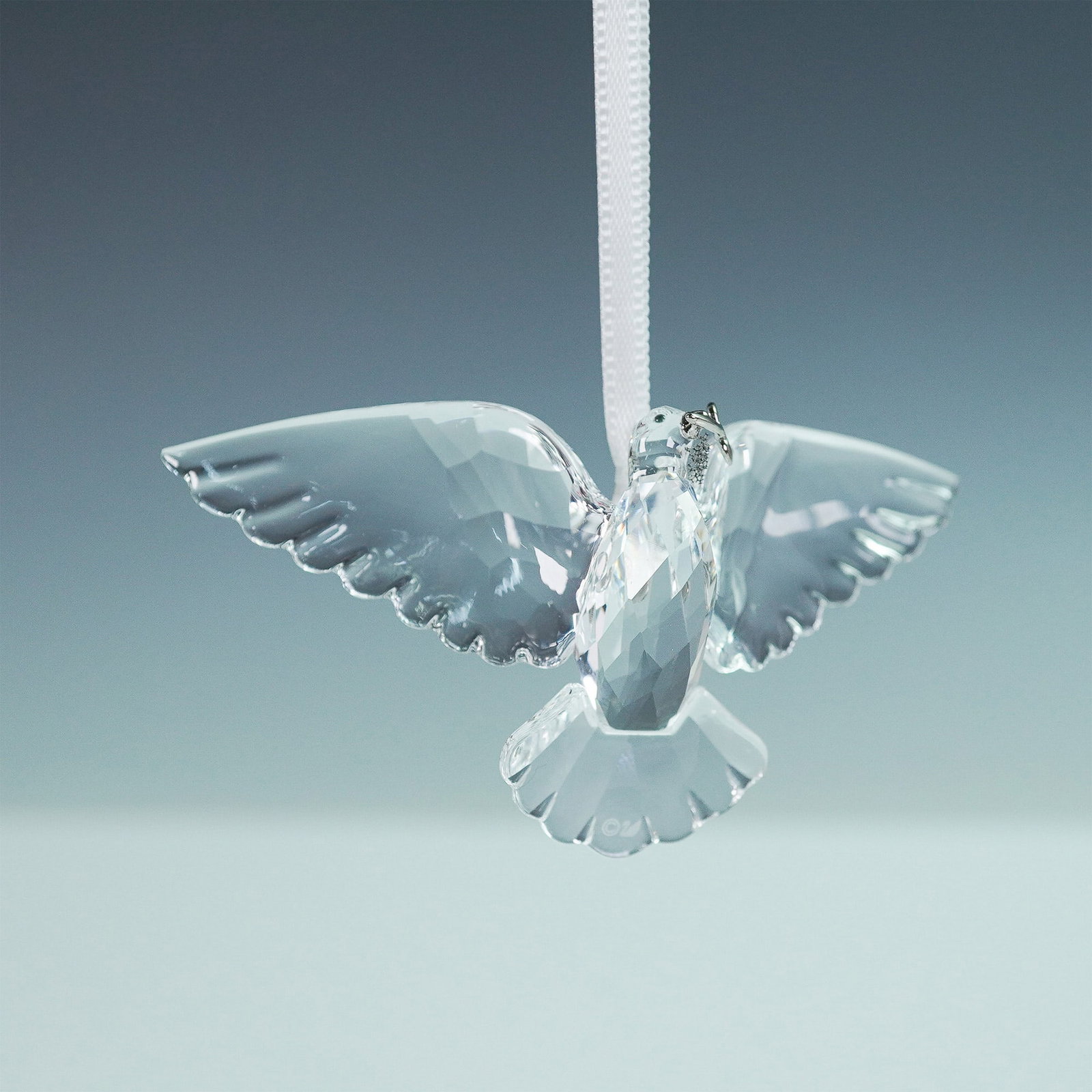 Swarovski Crystal Ornament, Peaceful Dove: This Swarovski crystal Peaceful Dove ornament features a beautifully faceted design, symbolizing harmony and grace. The dove is suspended from a white satin ribbon and adorned with a silver-tone olive