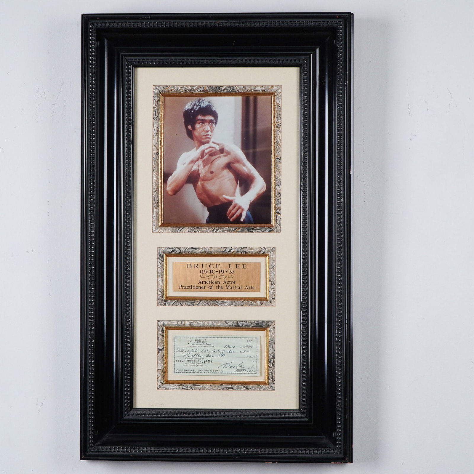 Bruce Lee Framed Signed Check Display: A striking framed memorabilia piece featuring a signed check by martial arts legend Bruce Lee. Dated November 2, 1968, this check is framed alongside a dynamic photograph of Lee in action and a commem