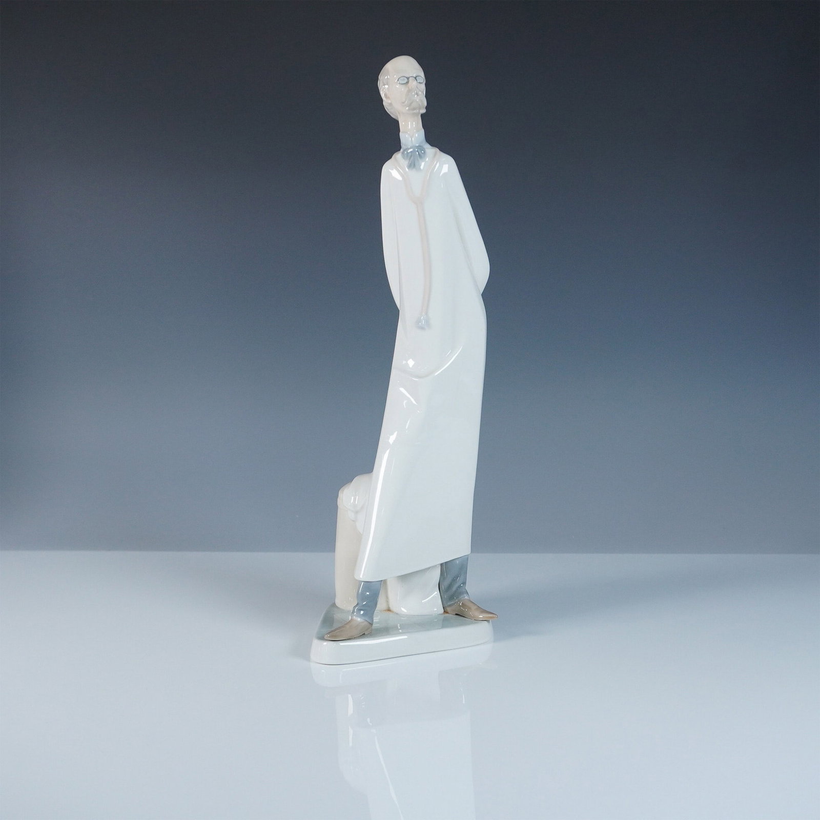 Lladro Porcelain Figurine, The Doctor: This Lladro porcelain figurine, item #1004602, depicts a distinguished doctor standing in a contemplative pose, representing the dedication and professionalism of the medical field. Crafted with Lladr