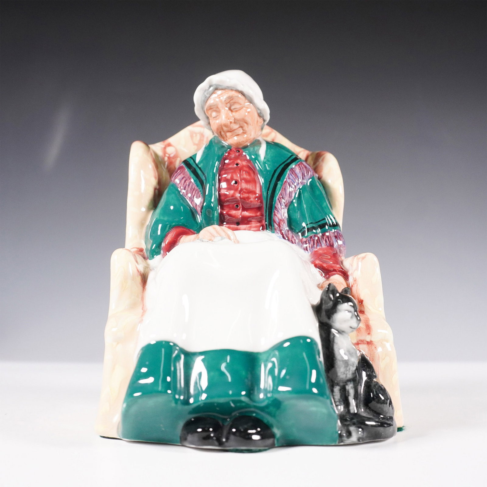 Royal Doulton Figurine, Forty Winks HN1974: Royal Doulton porcelain figurine titled Forty Winks, model number HN1974. This charming figurine depicts an elderly woman dozing in an armchair, draped in a green shawl over a red blouse, with a black
