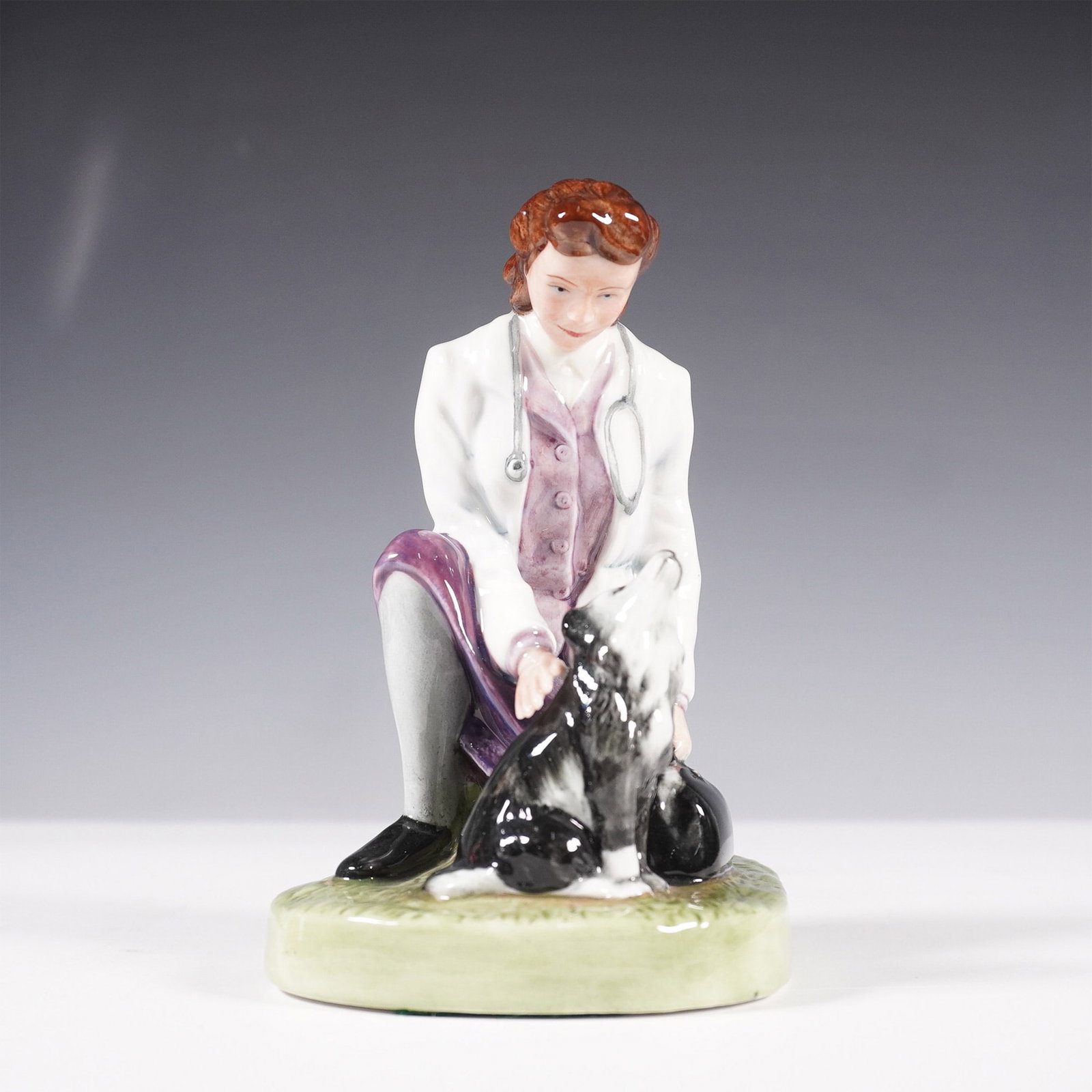 Royal Doulton Figurine, Town Veterinary HN4651, Signed: A Royal Doulton Classics figurine titled Town Veterinary, HN 4651, featuring a female veterinarian in a white coat and stethoscope tending to a black and white dog. Designed by Marilyn G. Hutchings an