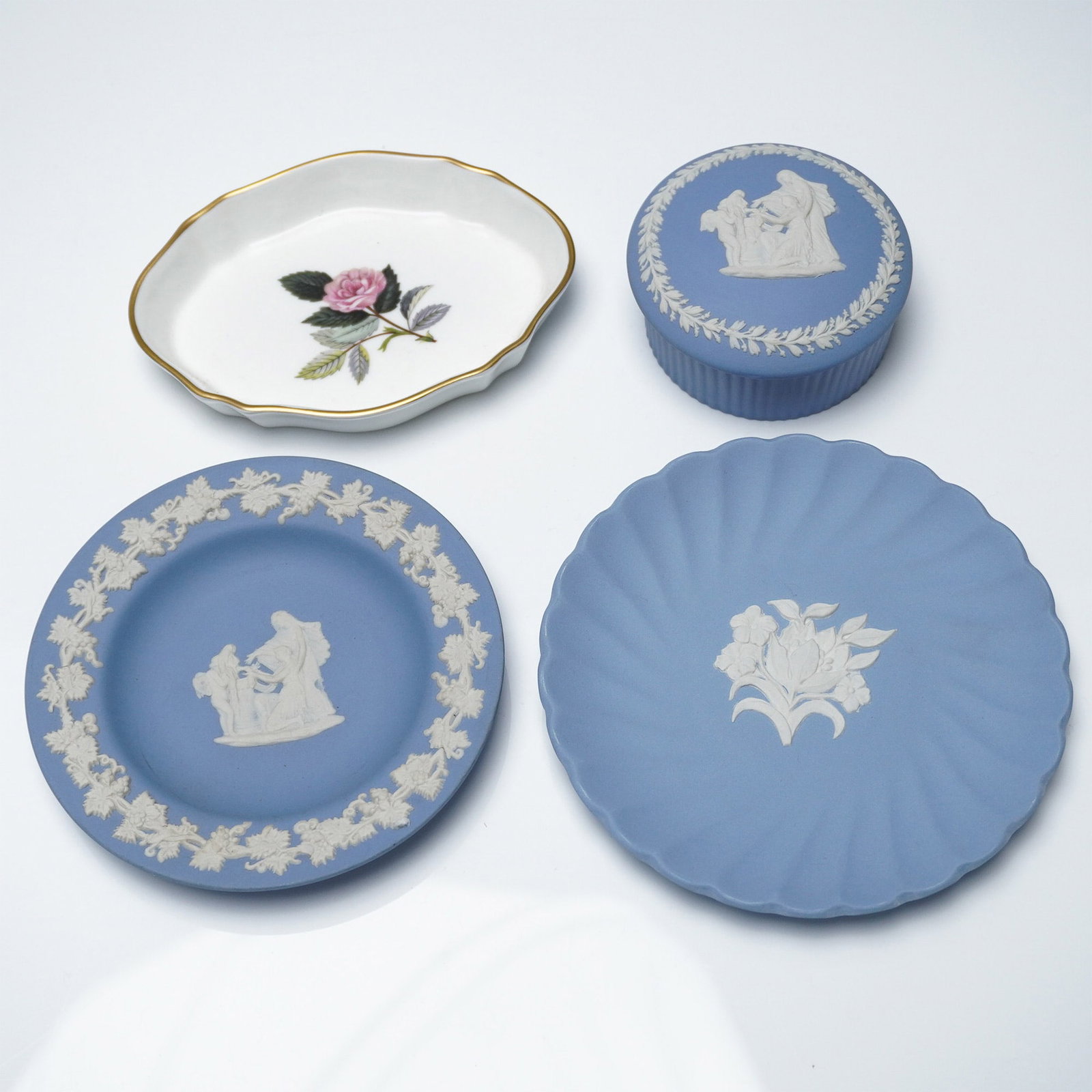 4pc Wedgwood Jasperware and Bone China Dish Collection: A collection of four Wedgwood decorative pieces, featuring three classic Jasperware items and one bone china dish. The Jasperware pieces include a lidded trinket box and two plates, all in the iconic 