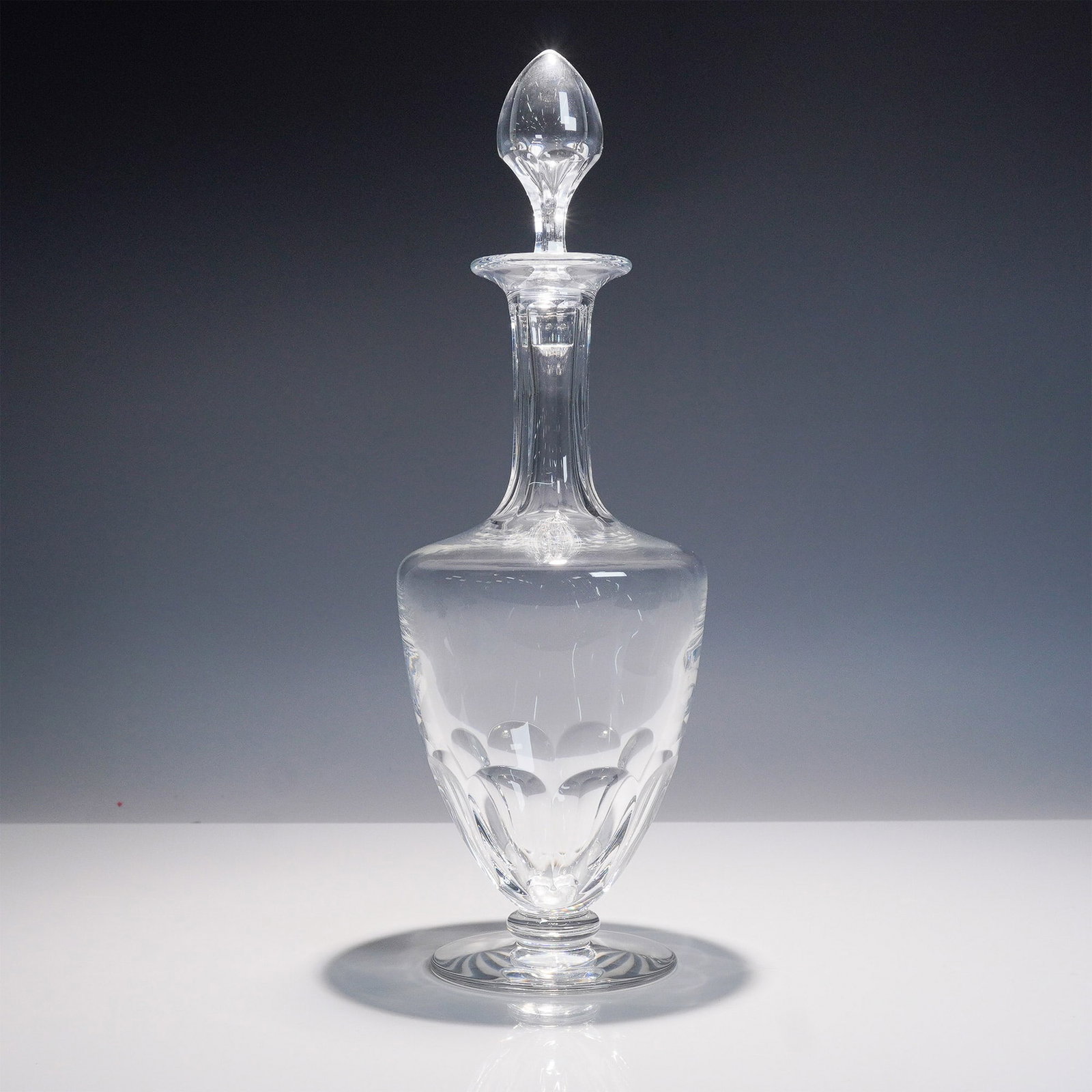 Baccarat Capri Crystal Decanter with Stopper: A stunning Baccarat Capri crystal decanter featuring an elegant tapered form with vertical cut detailing and a faceted stopper. This sophisticated piece exudes timeless luxury, crafted with the precis