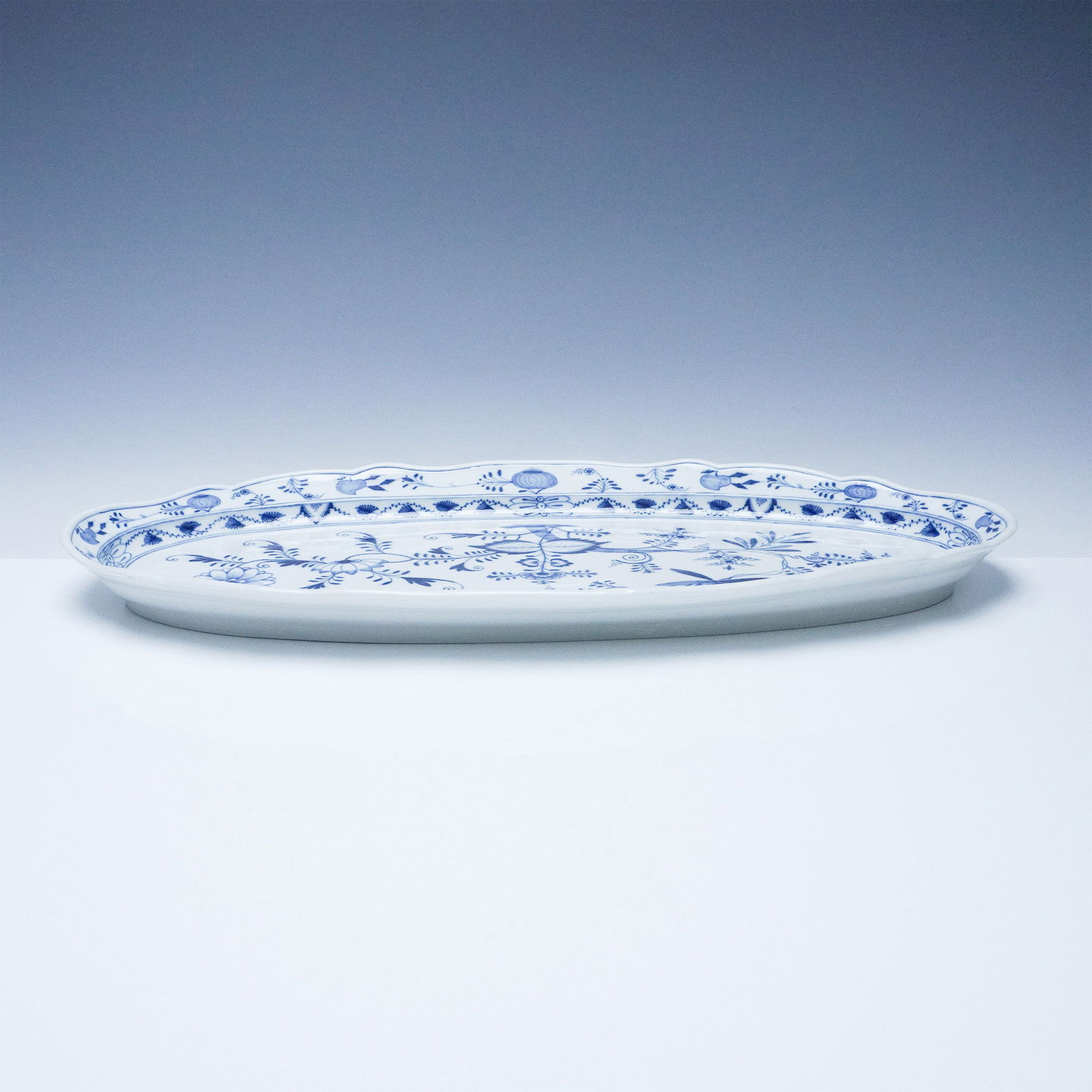 Meissen Blue Onion Porcelain Platter with Crossed Swords Mark: A fine Meissen porcelain platter featuring the iconic Blue Onion pattern, meticulously hand-painted in cobalt blue. The design showcases an intricate floral and foliate composition with stylized bloom