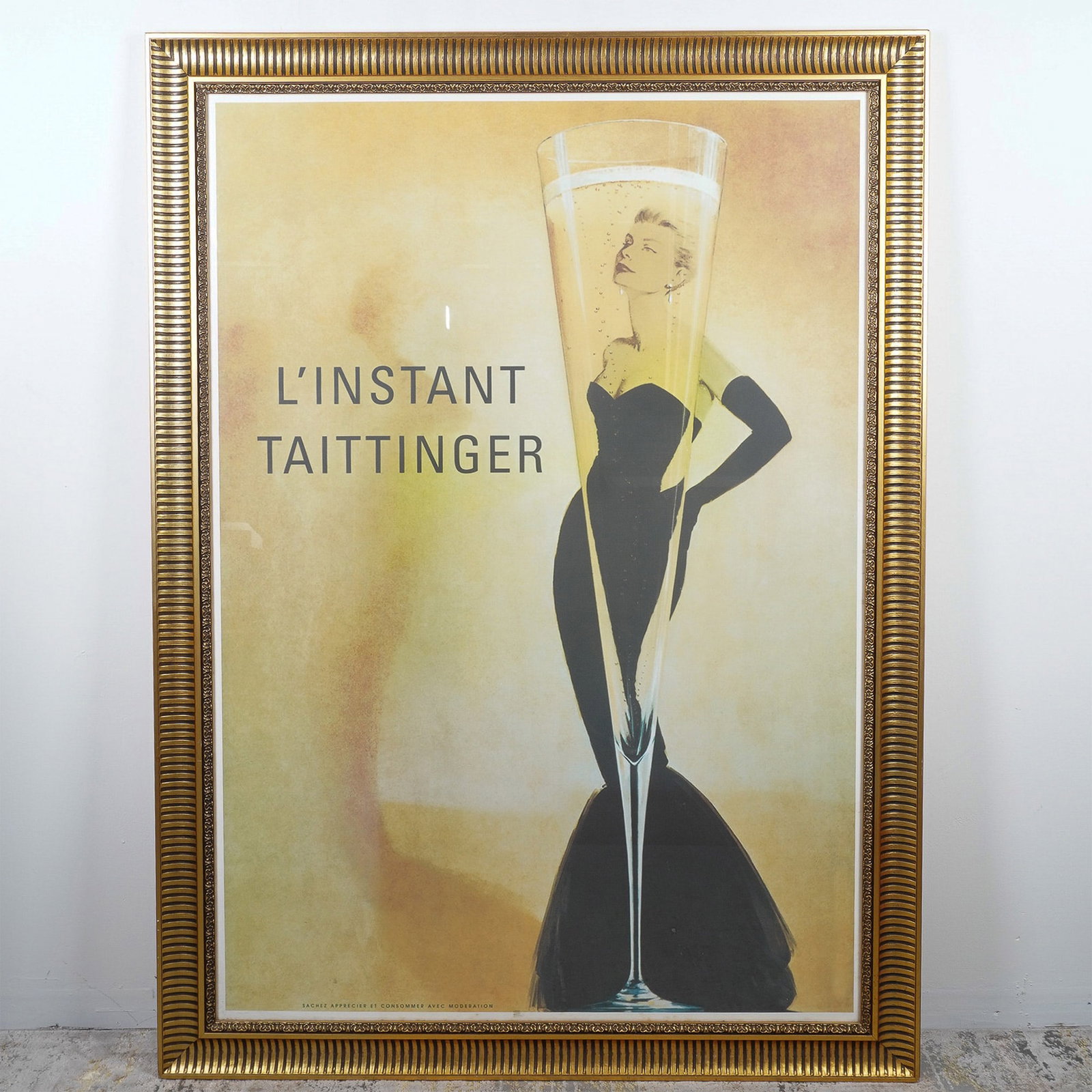 Massive Framed L'Instant Taittinger Champagne Poster: A huge framed poster of the iconic L'Instant Taittinger Champagne advertisement. This elegant artwork features a sophisticated woman seamlessly blending into a tall champagne flute, a striking represe