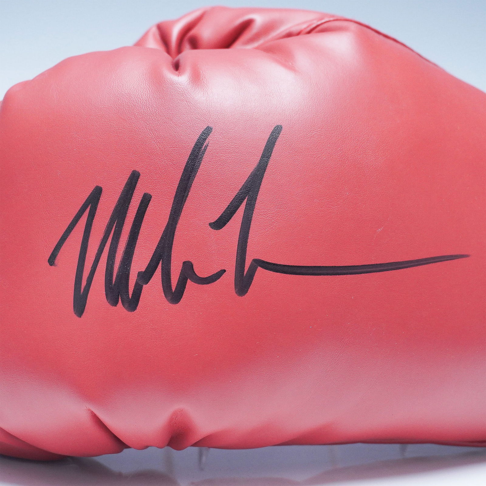 Everlast Boxing Glove, Signed by Mike Tyson: Featured is an Everlast red boxing glove, hand-signed by legendary heavyweight champion Mike Tyson. This professional-style glove is constructed from high-quality synthetic leather and showcases black