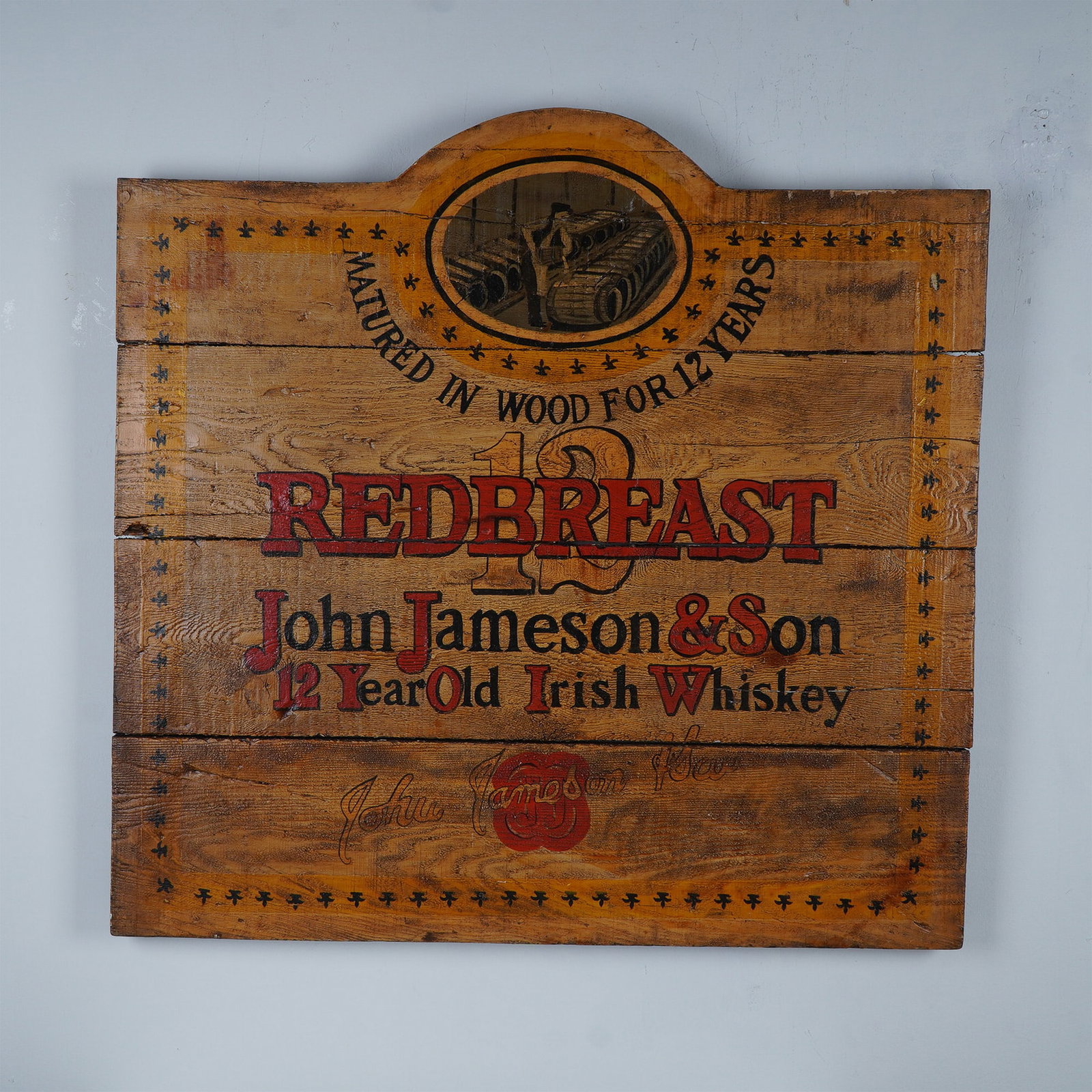Redbreast John Jameson & Son 12 Year Irish Whiskey Wooden Advertising Sign: Handsome wooden advertising sign for Redbreast John Jameson & Son 12 Year Old Irish Whiskey, crafted in a rustic style reminiscent of aged whiskey barrels. The hand-painted design features bold red an