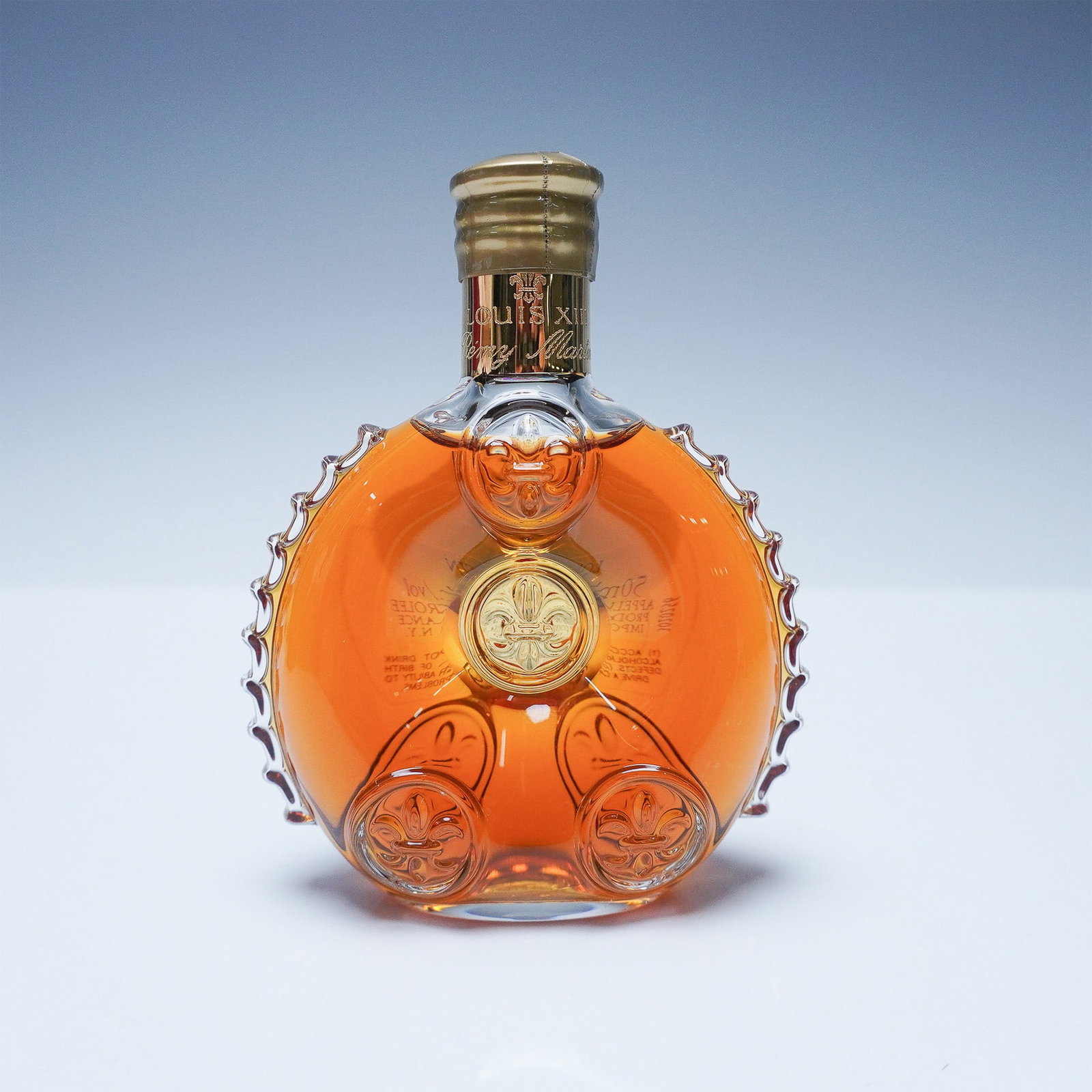 Remy Martin Louis XIII Cognac Miniature, 50ml: A remarkable Remy Martin Louis XIII Cognac miniature, elegantly housed in a 50ml crystal decanter, adorned with the iconic fleur-de-lis motif. Comprising a blend of up to 1,200 eaux-de-vie, some aged 