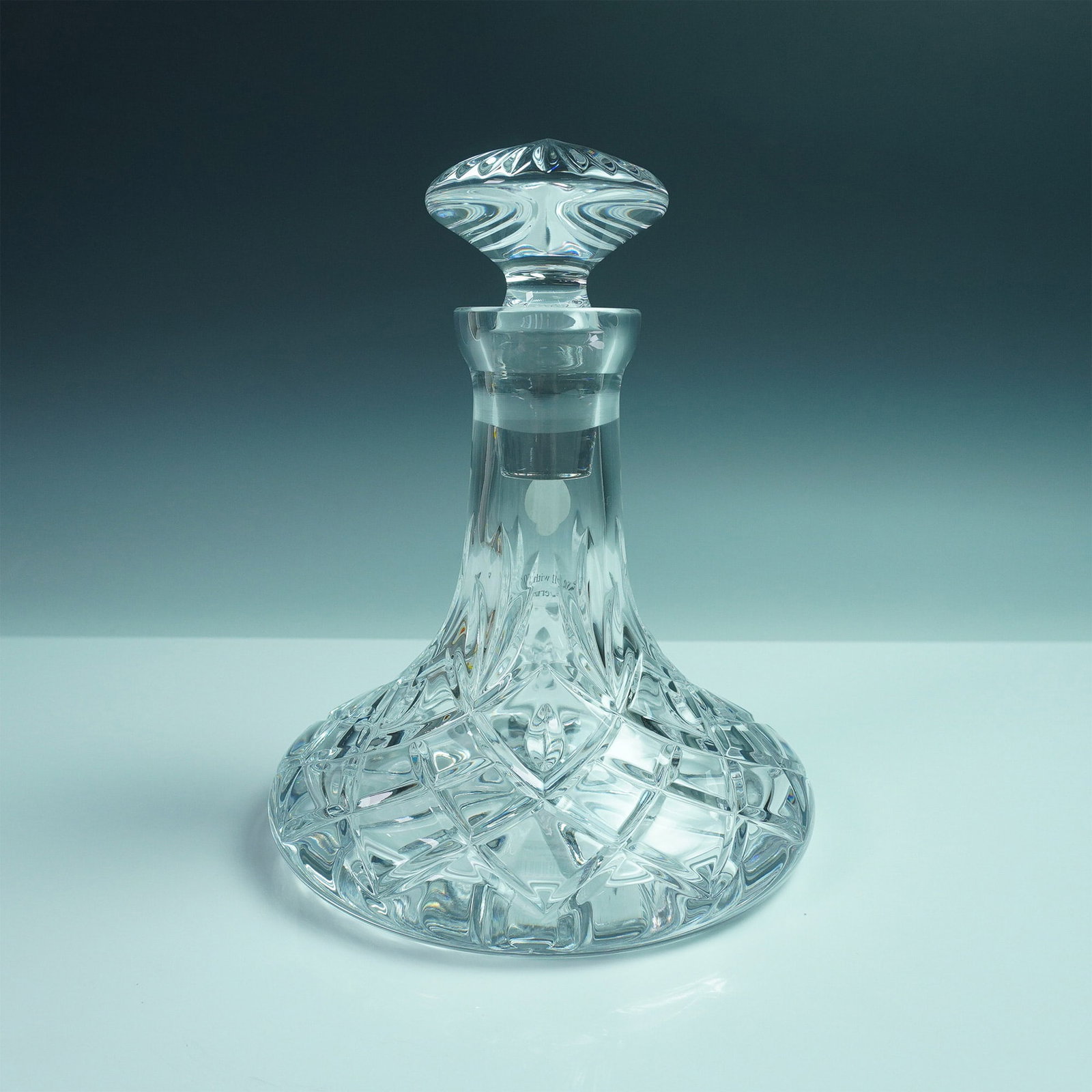 Waterford Crystal Mini Ship Decanter, Huntley: Crafted in clear crystal with crisscross and vertical cuts throughout the body and stopper. The design features a broad base and narrow neck, typical of the ship decanter form. Acid-etched Waterford m