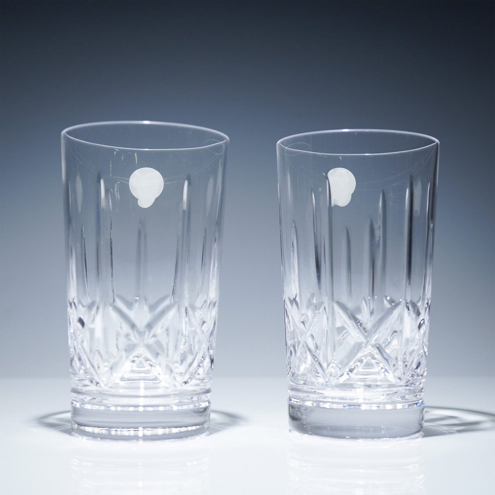 Pair of Waterford Crystal Highball Glasses, Eimer: Set of two Waterford lead crystal highball glasses in the Eimer pattern. Each glass is made of clear crystal and features vertical and criss-cross cuts. The base of each glass is marked with the etche