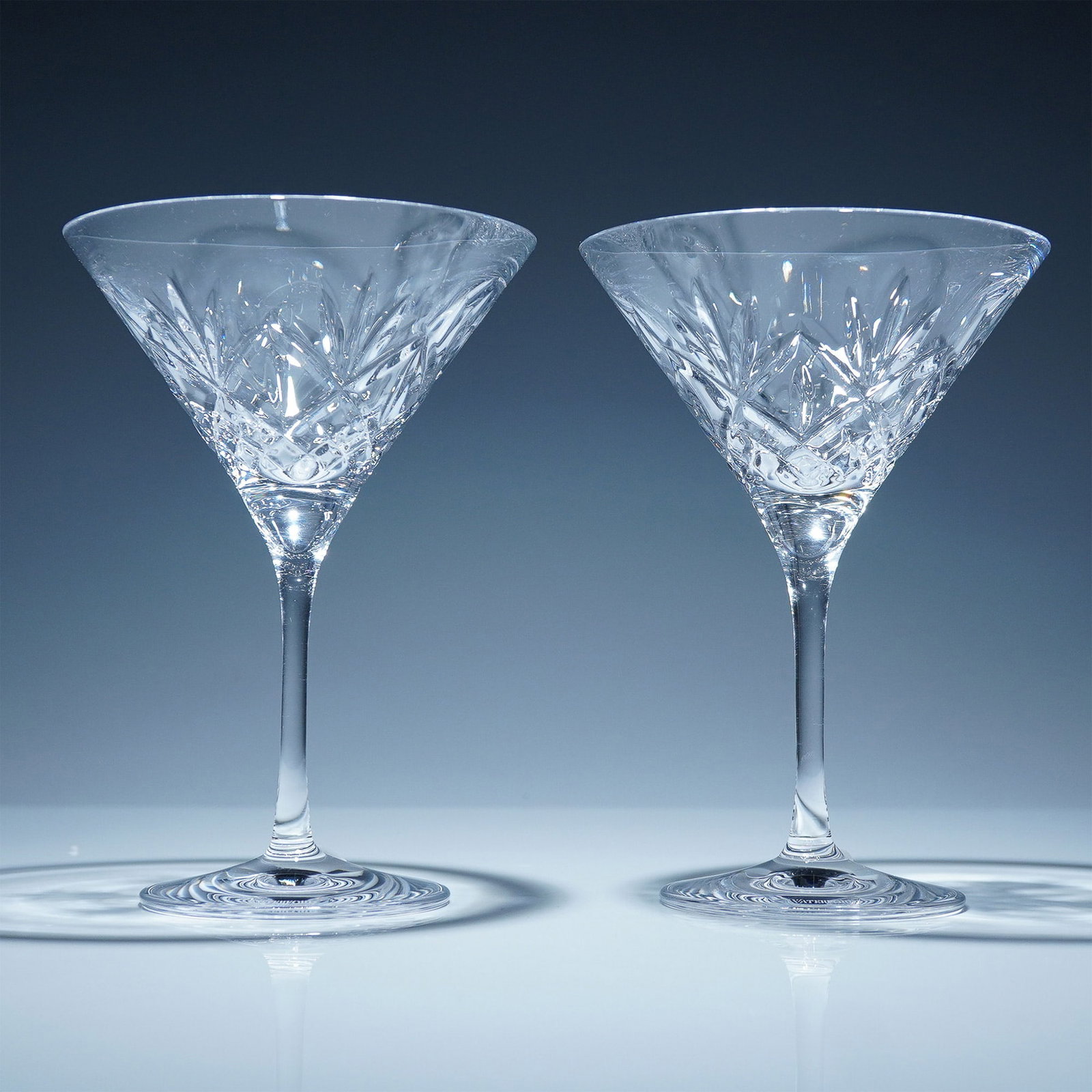 Pair of Waterford Crystal Martini Glasses, Huntley: Set of 2 Waterford crystal martini glasses from the Huntley collection. Each glass is crafted in clear crystal and features a cut criss-cross and fan motif. The base of each glass is etched with the W