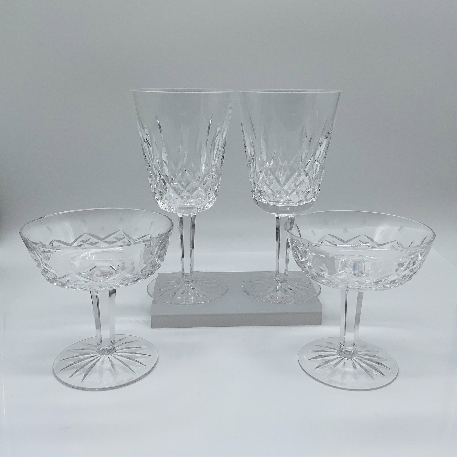 4pc Waterford Crystal Glassware: A stunning set of Waterford crystal glassware, featuring two tall water goblets and two champagne coupes. Each piece displays a brilliant diamond-cut pattern, characteristic of Waterford's renowned cr