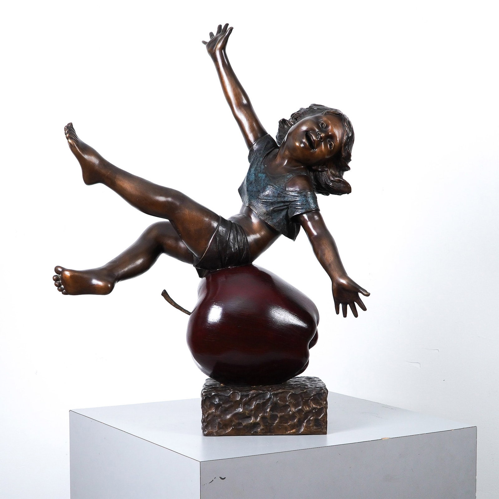 Bronze Sculpture by Nifao, Girl Having Fun on Apple: A charming polychrome bronze sculpture by Nifao titled Girl Having Fun on Apple, featuring a young girl joyfully balancing atop a large, richly patinated apple that symbolizes knowledge and innocence.
