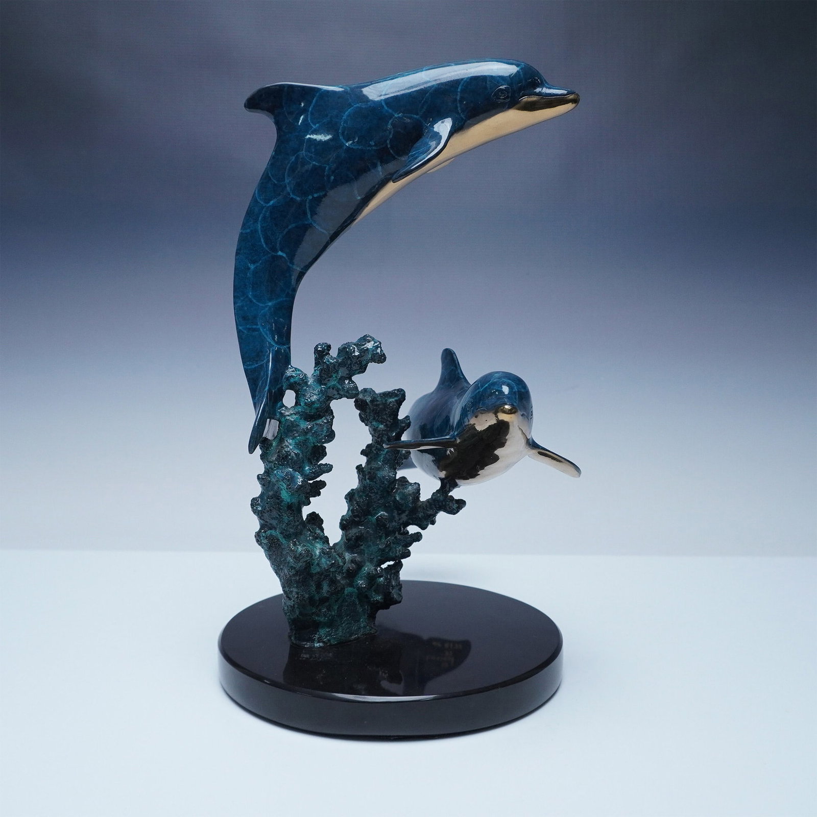 Christian Riese Lassen Bronze Dolphin Sculpture, 1993, AP 8/75: This limited edition bronze sculpture by renowned marine artist Christian Riese Lassen depicts two dolphins gracefully leaping over coral. Signed Lassen 93 and marked AP 8/75, this Artist's Proof is p